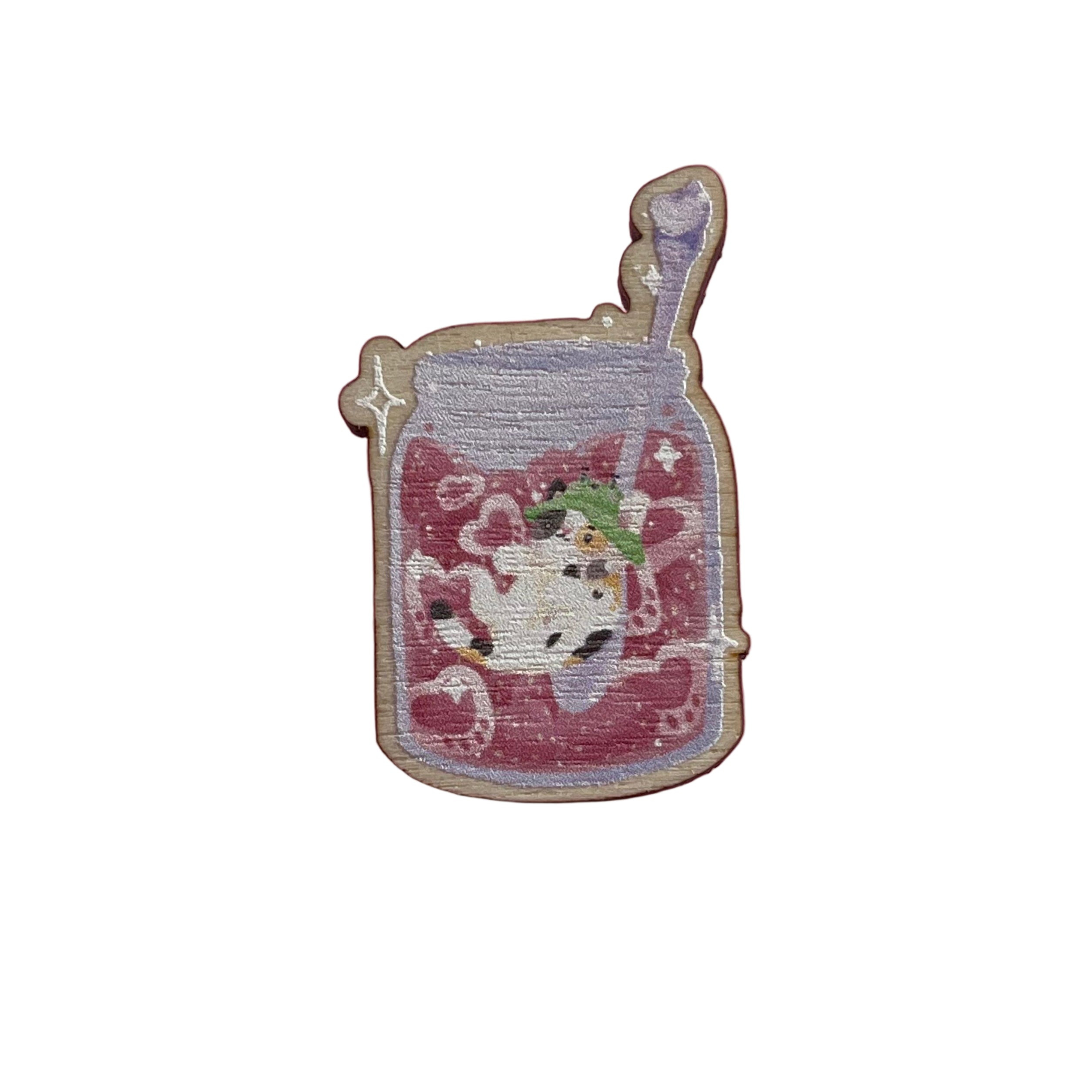 Wooden pin badge of a pawberry (heart-shaped strawberries with a paw shape inside) jam jar, with Bucket the calico cat inside. The spoon has a bee on it. This badge is printed onto 3mm thick responsibly sourced European birch plywood.