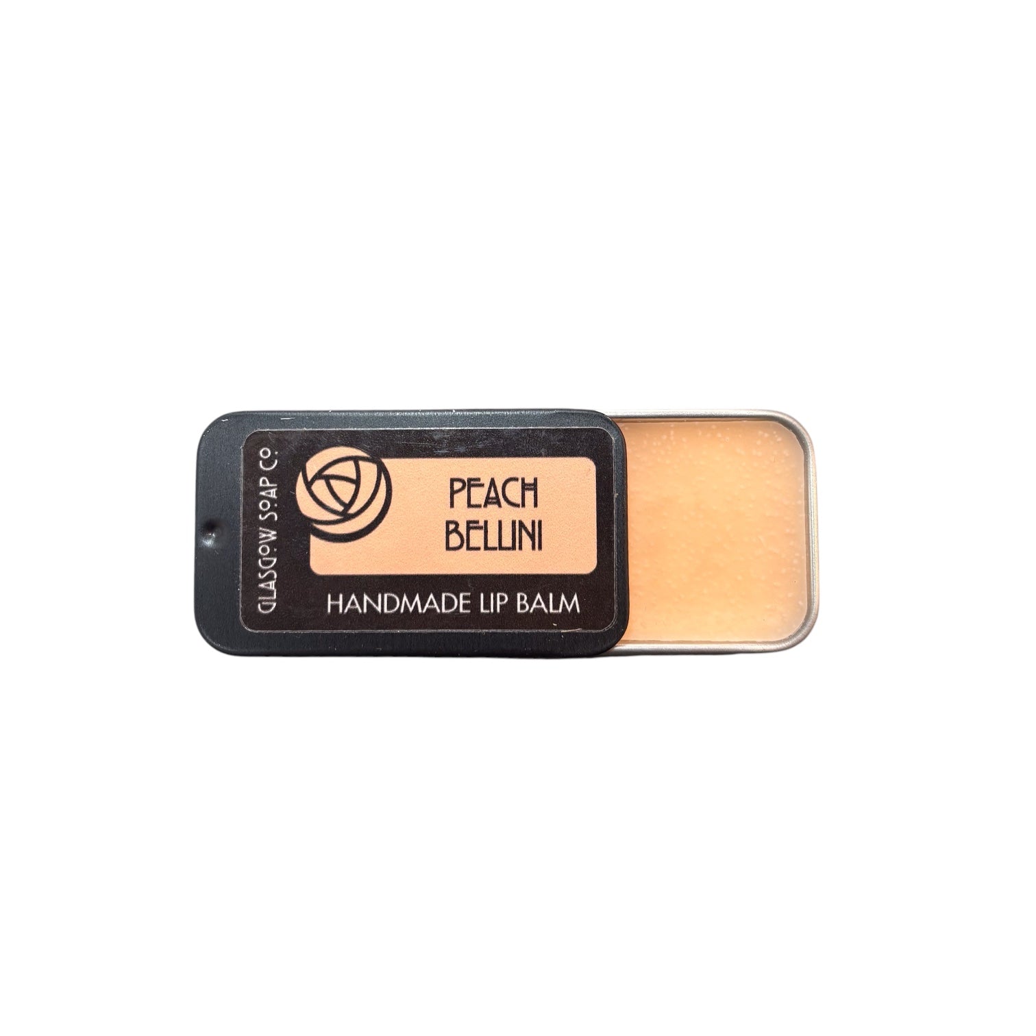A small black tin of peach bellini lip balm, half open.