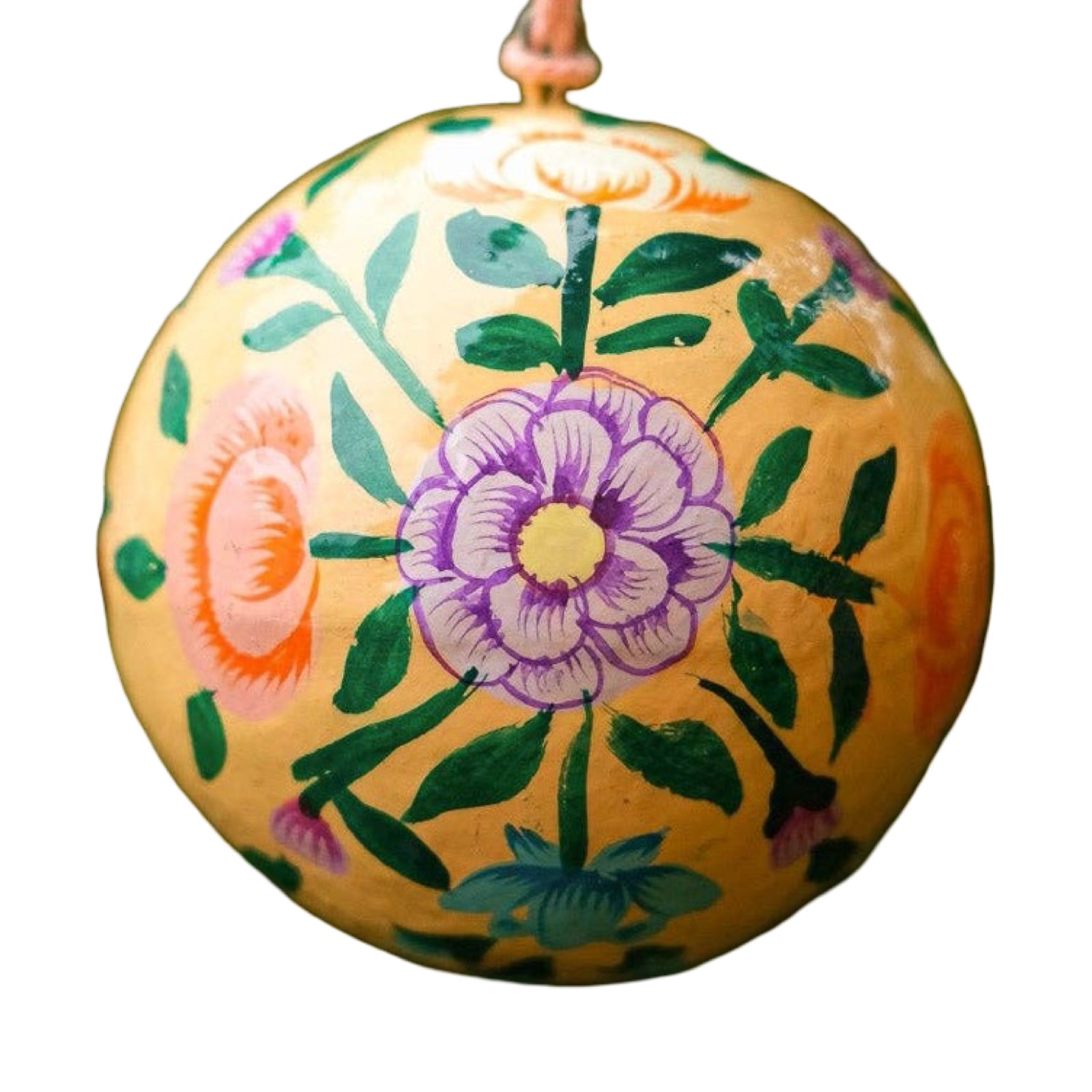 A round papier mache bauble in peach with a lilac, orange, green and turquoise floral design.