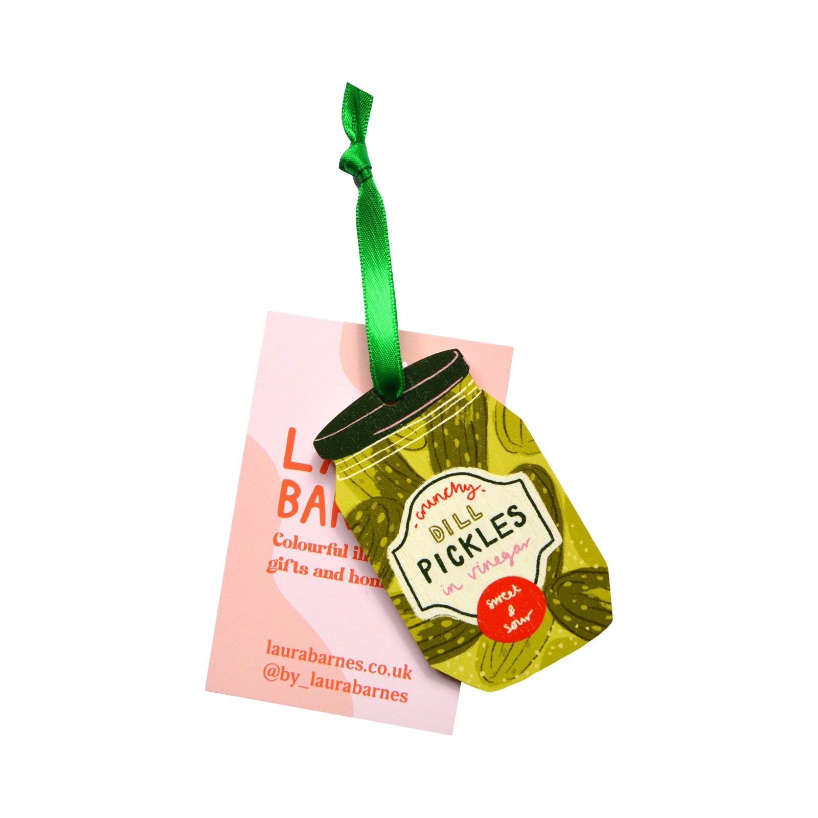 Decorative pickles jar ornament with a green ribbon on a pink card, branded 'Laura Barnes'.