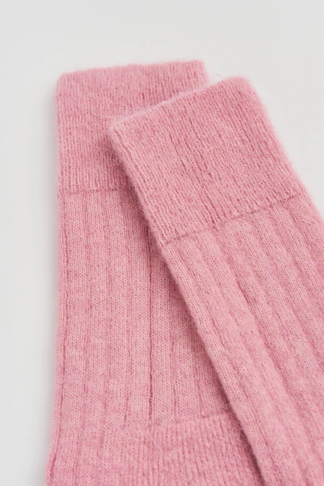 Top of pink socks on a white background.