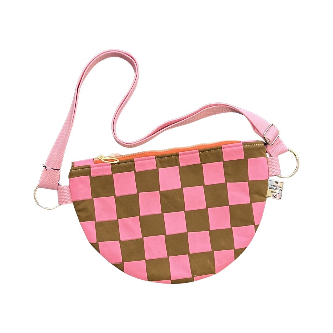 Pink and brown checked cross body bag with adjustable strap.