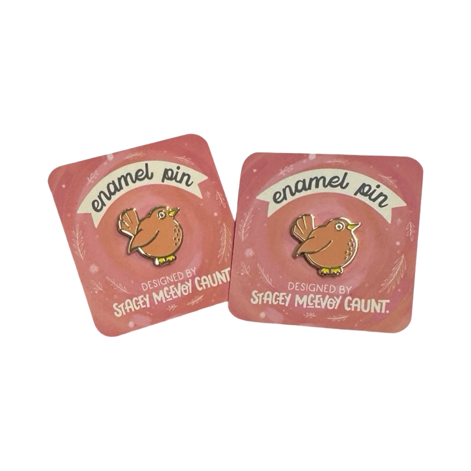 Two pink card packaging with an enamel pin featuring a bird design on a white background.