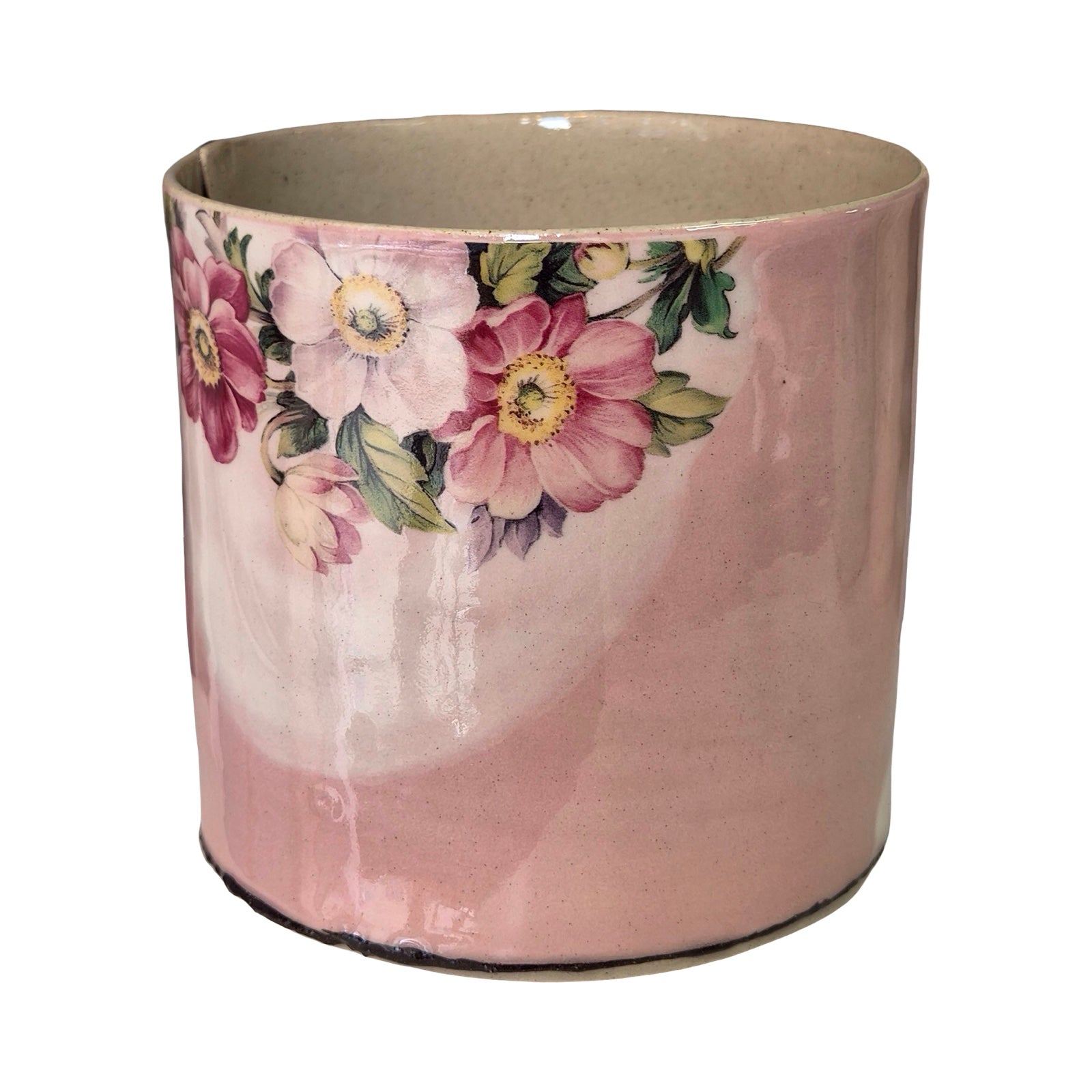 Pink ceramic planter with floral design on a white background.