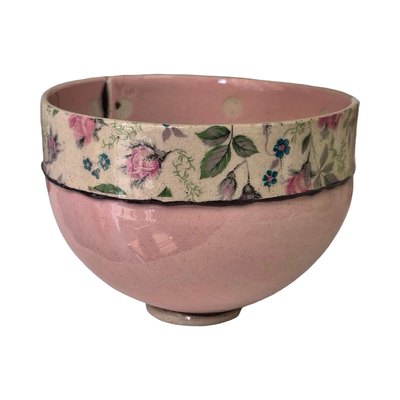 Pink ceramic bowl with floral patterned band on a white background.