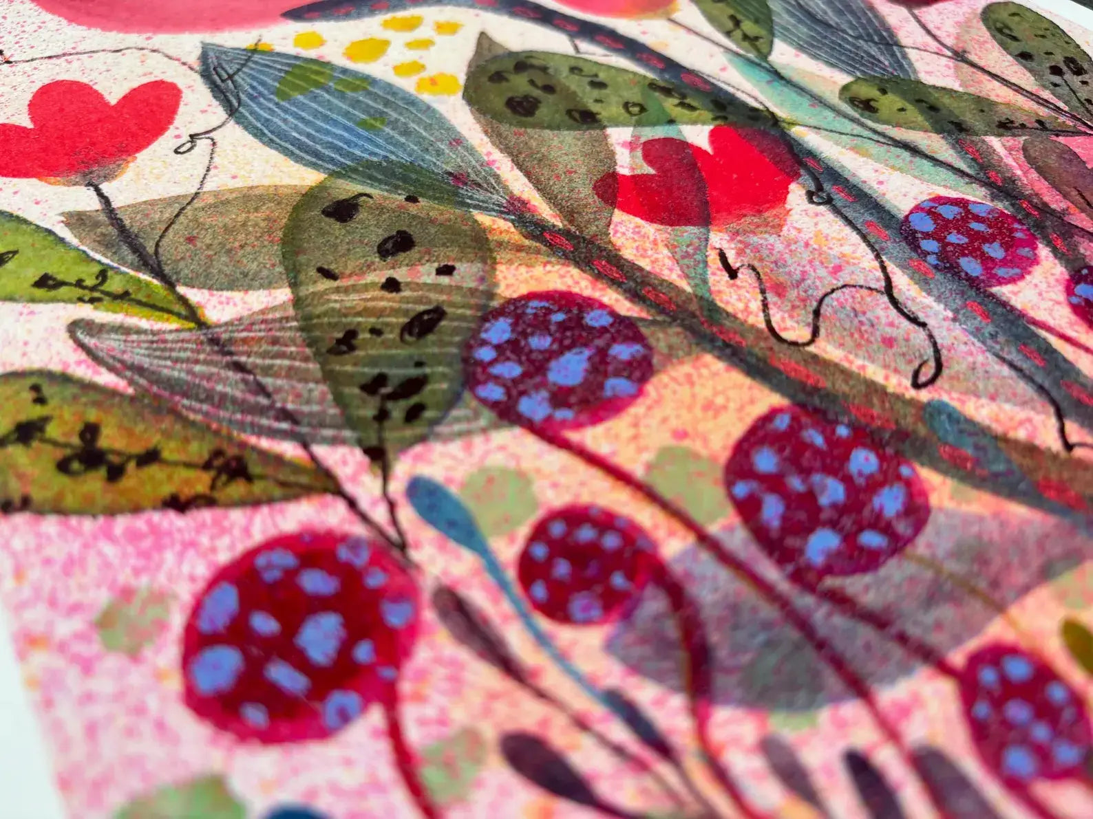 Close-up of a colourful art print with floral patterns and red hearts.