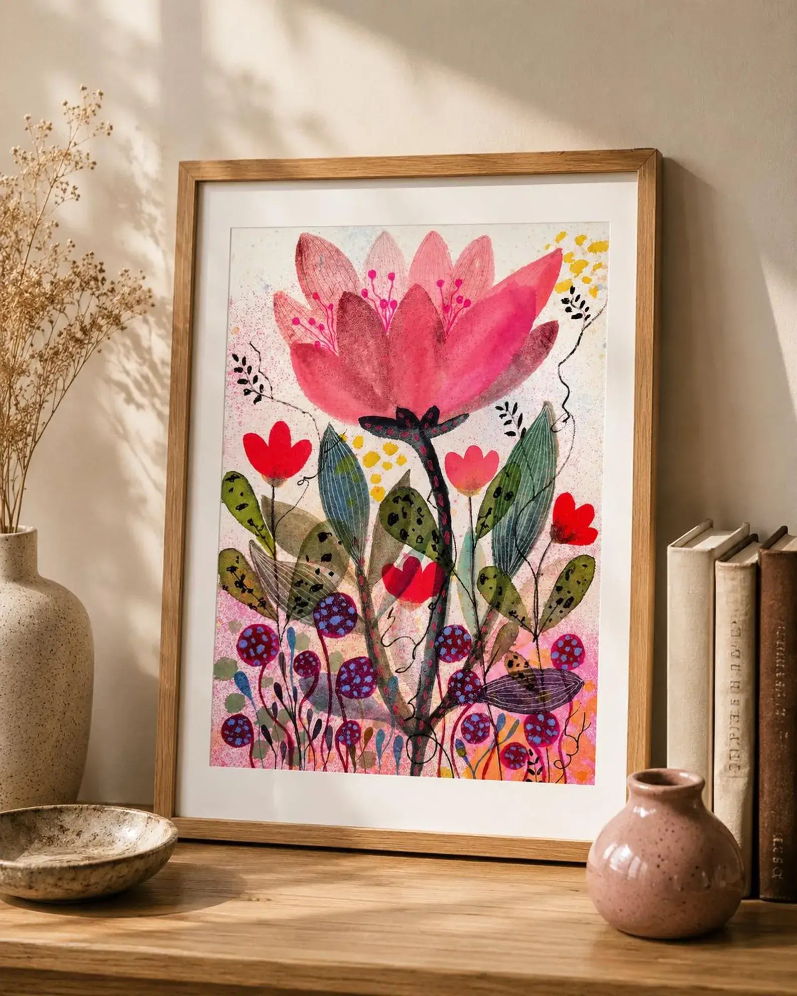 Framed floral artwork on a wooden shelf with decorative items.