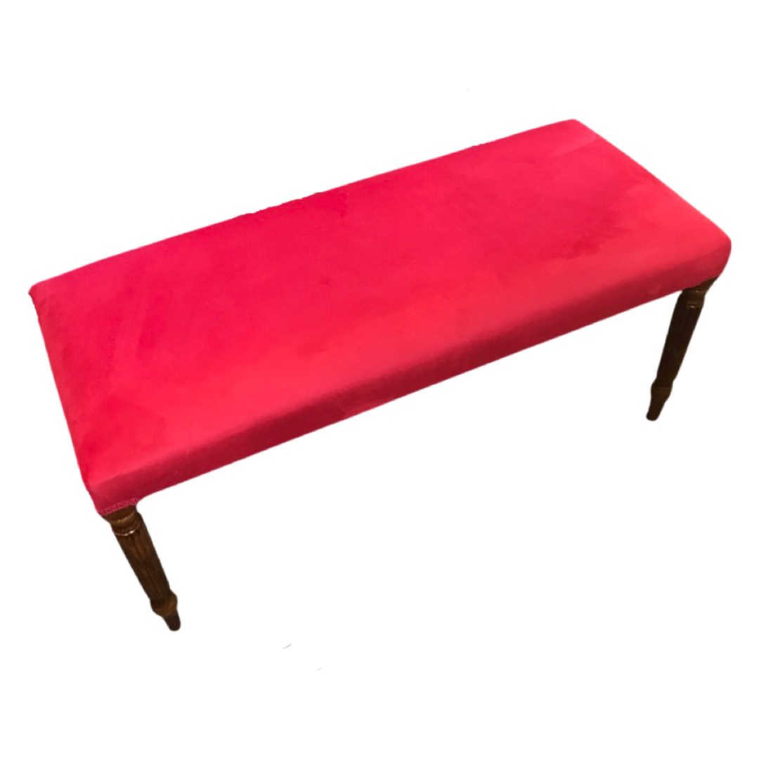 A rectangular velvet bench with mahogany stained legs in a pink colour design.