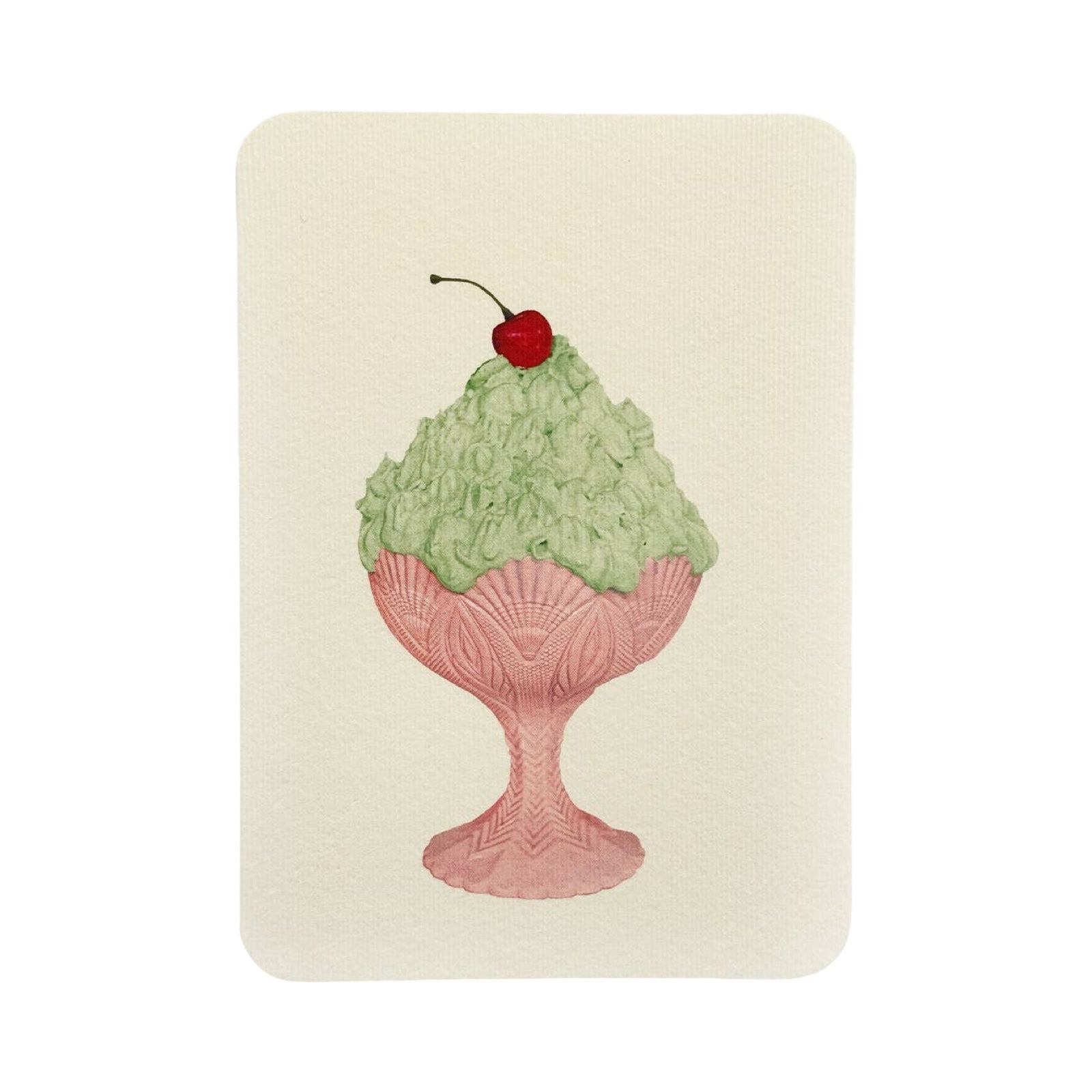 Green ice cream in a pink dish with a cherry on top on a beige background.