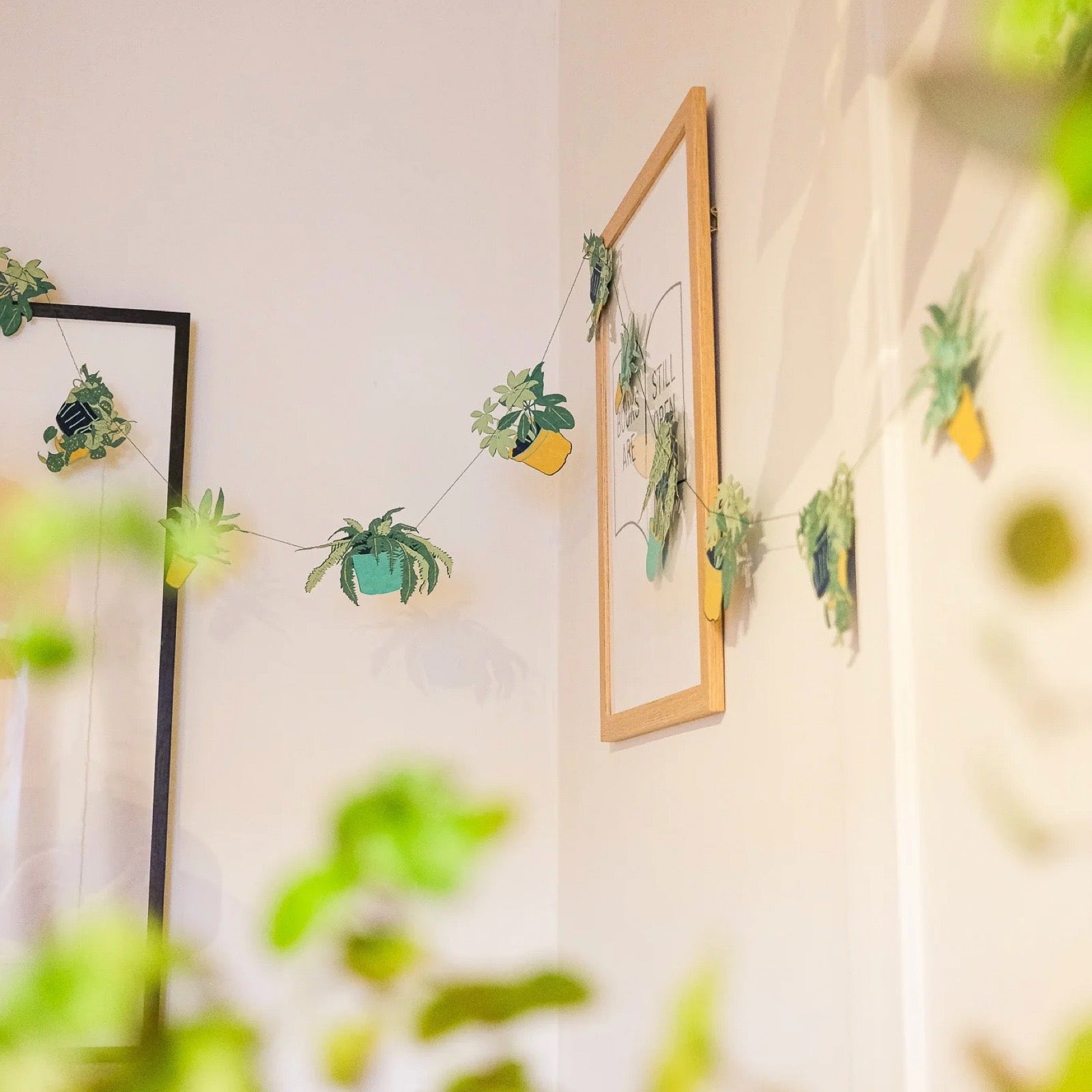 Decorative string with small potted plants hanging on a wall.
