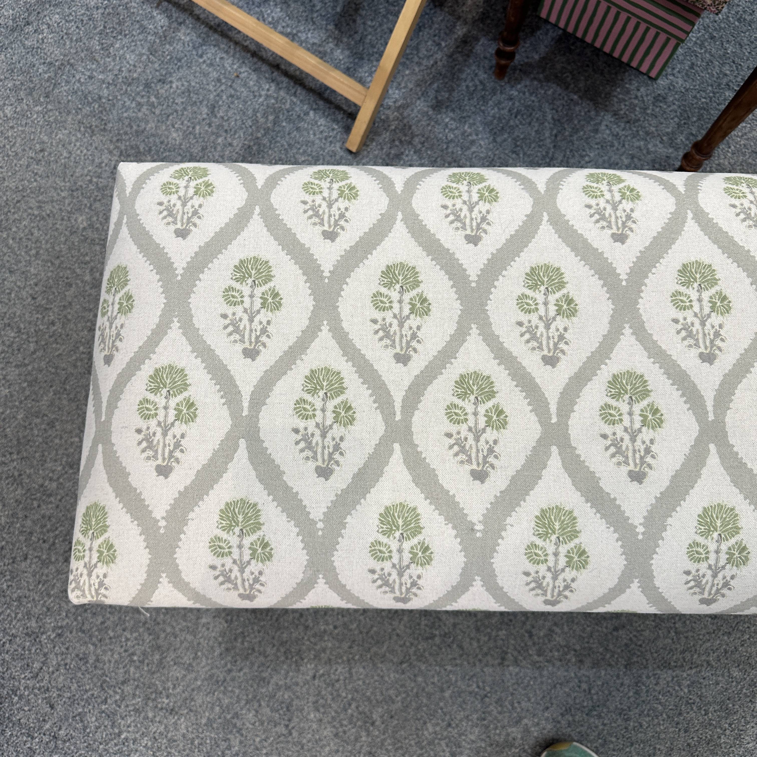 Patterned bench on a grey carpet.