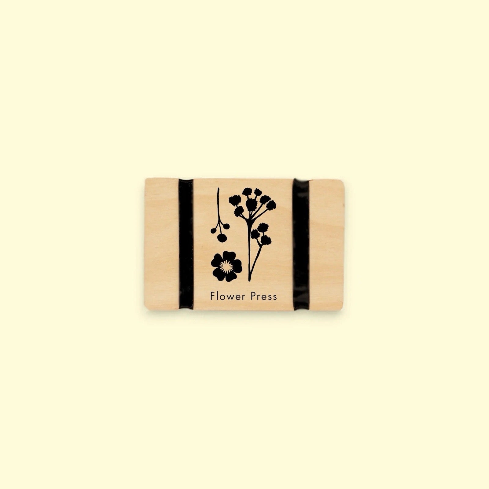 Rectangular wooden flower press with floral design and 'Flower Press' text on a beige background.