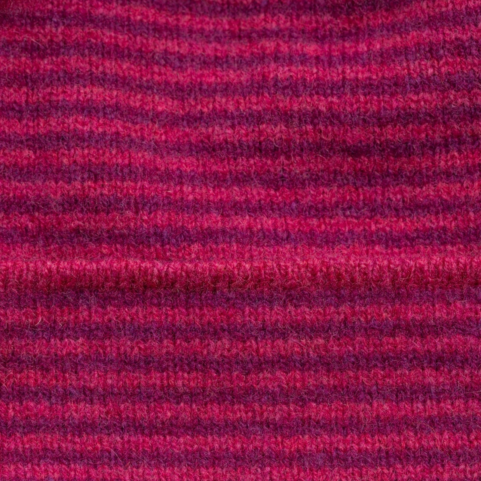 Close-up of a fabric with a striped pattern in shades of purple and red.