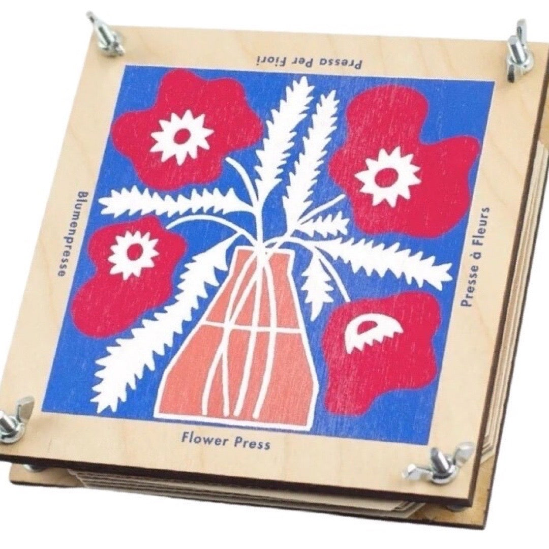 Wooden flower press with floral design on a blue background.