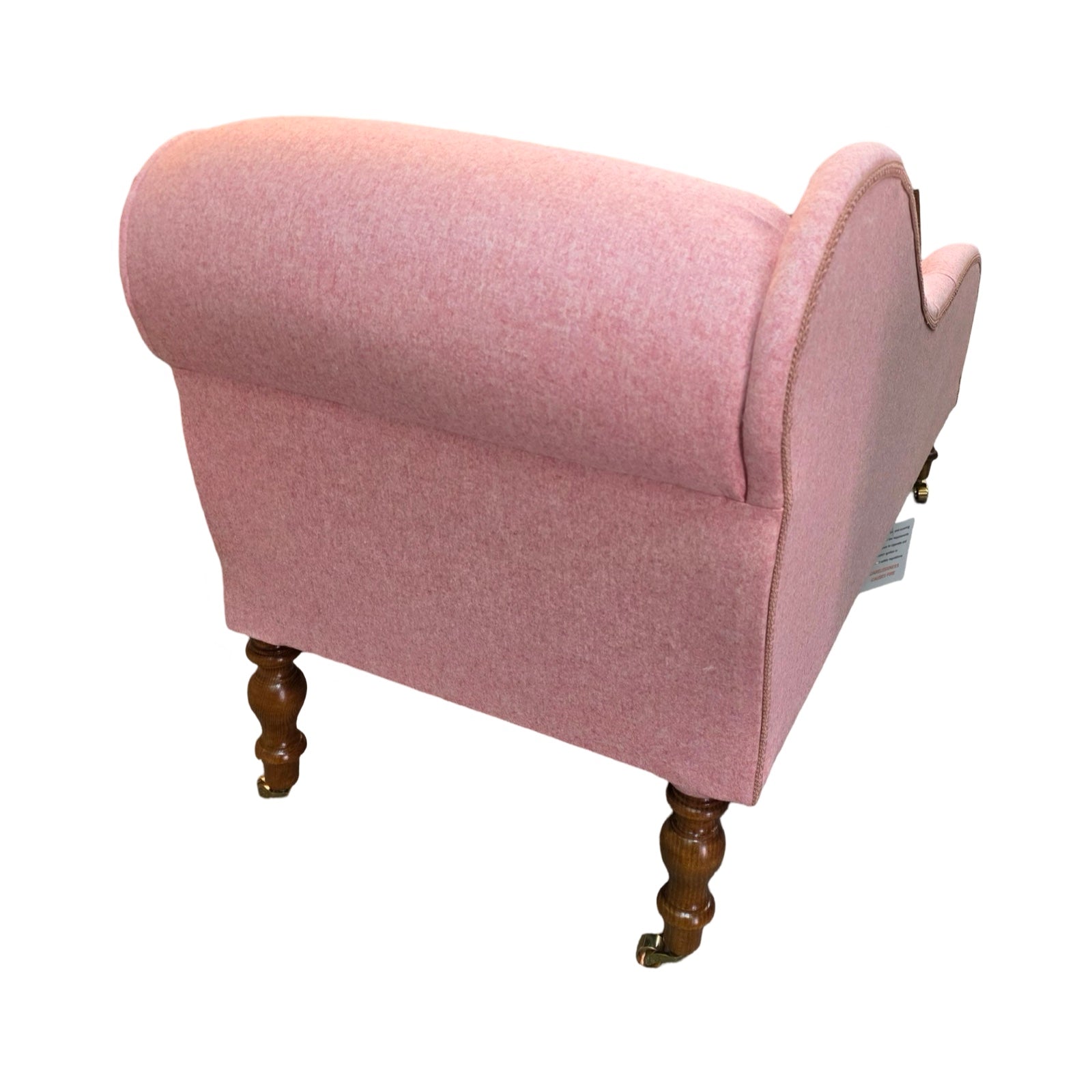 The side of a handcrafted chaise lounge in gorgeous powder pink wool mix fabric.