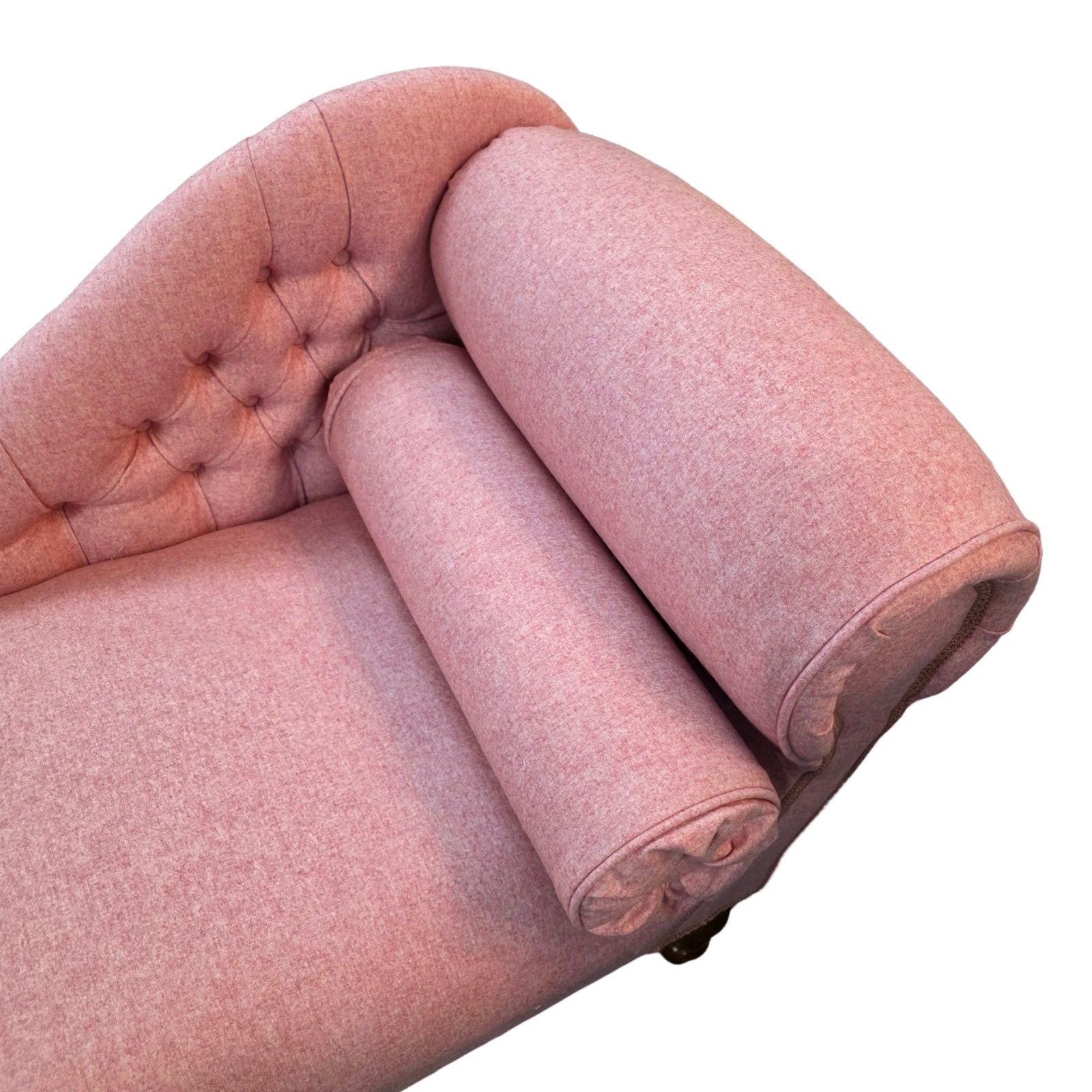The arm detail of a handcrafted chaise lounge in gorgeous powder pink wool mix fabric.