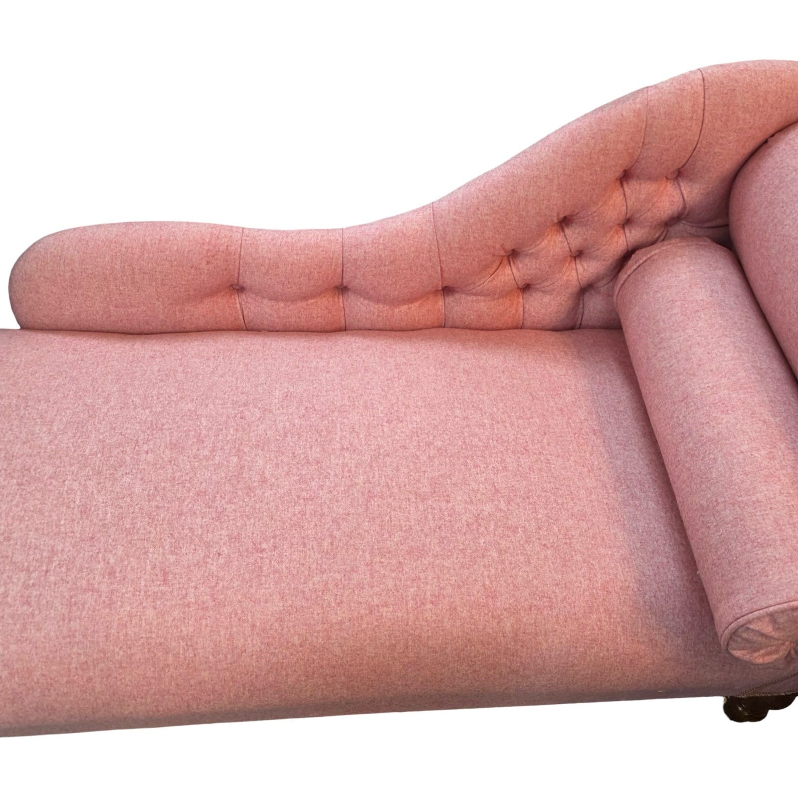 The button back of a handcrafted chaise lounge in gorgeous powder pink wool mix fabric.