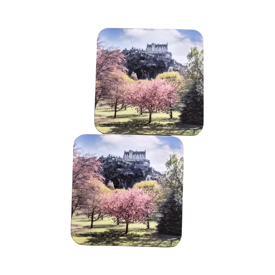 Two coasters with a scenic design of cherry blossoms and a castle.