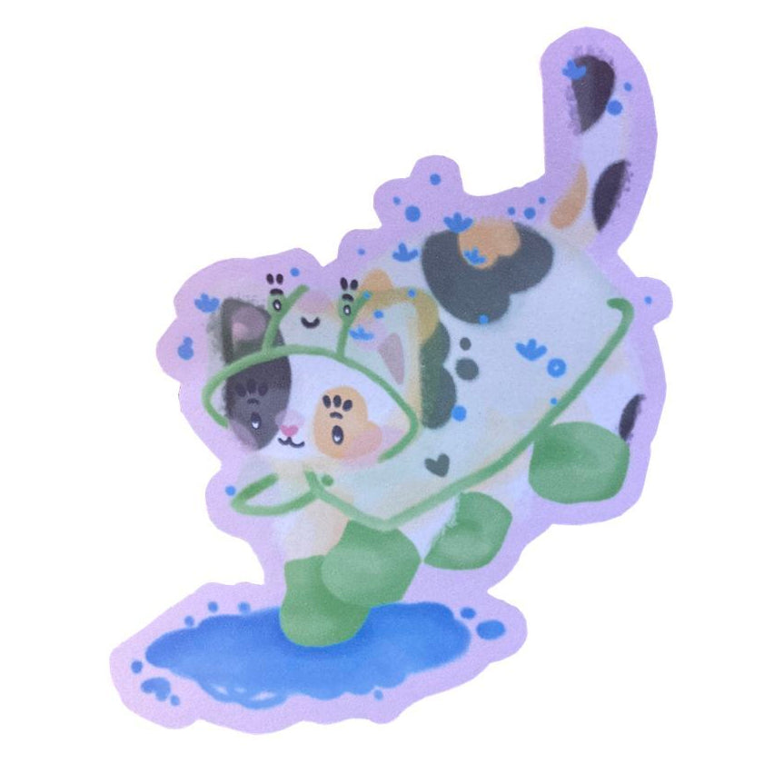 Sticker of a calico cat wearing a green frog raincoat and rainboots, jumping down into a puddle