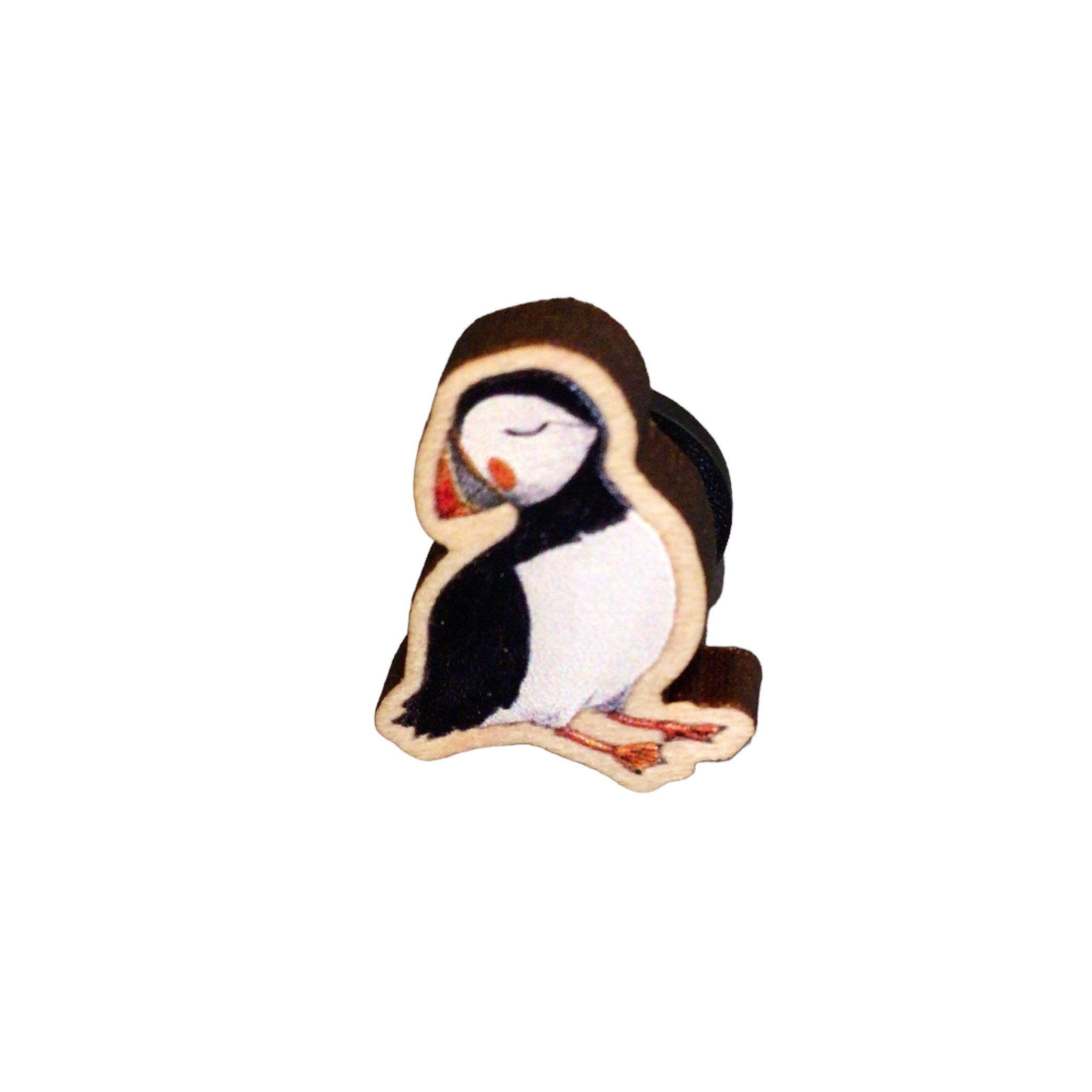 A mini wooden pin badge of a puffin.