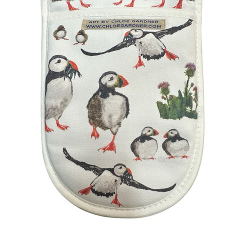 White oven gloves featuring multiple puffins, flying and standing and clusters of thistles.