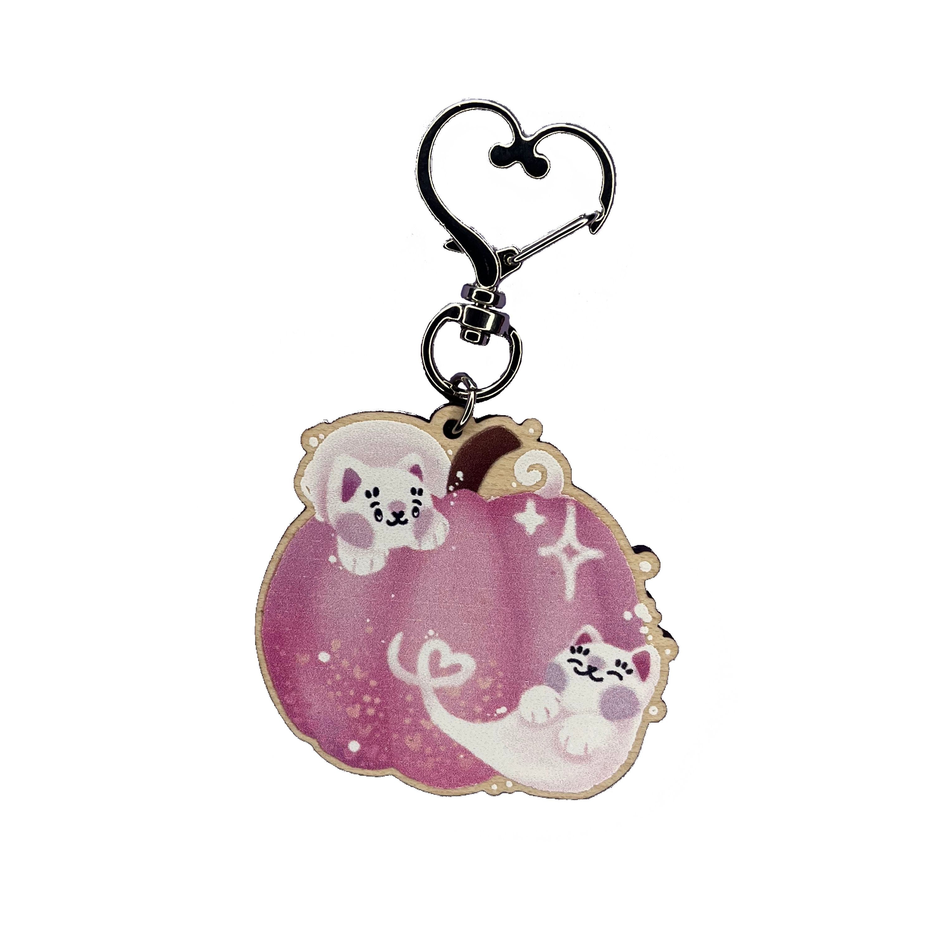 Wooden keyring with silver, heart-shaped lobster clasp. Pink pumpkin jack-o-lantern with two cat ghosts in this keyring design. This keyring is printed onto 4mm thick responsibly sourced UK maplewood.