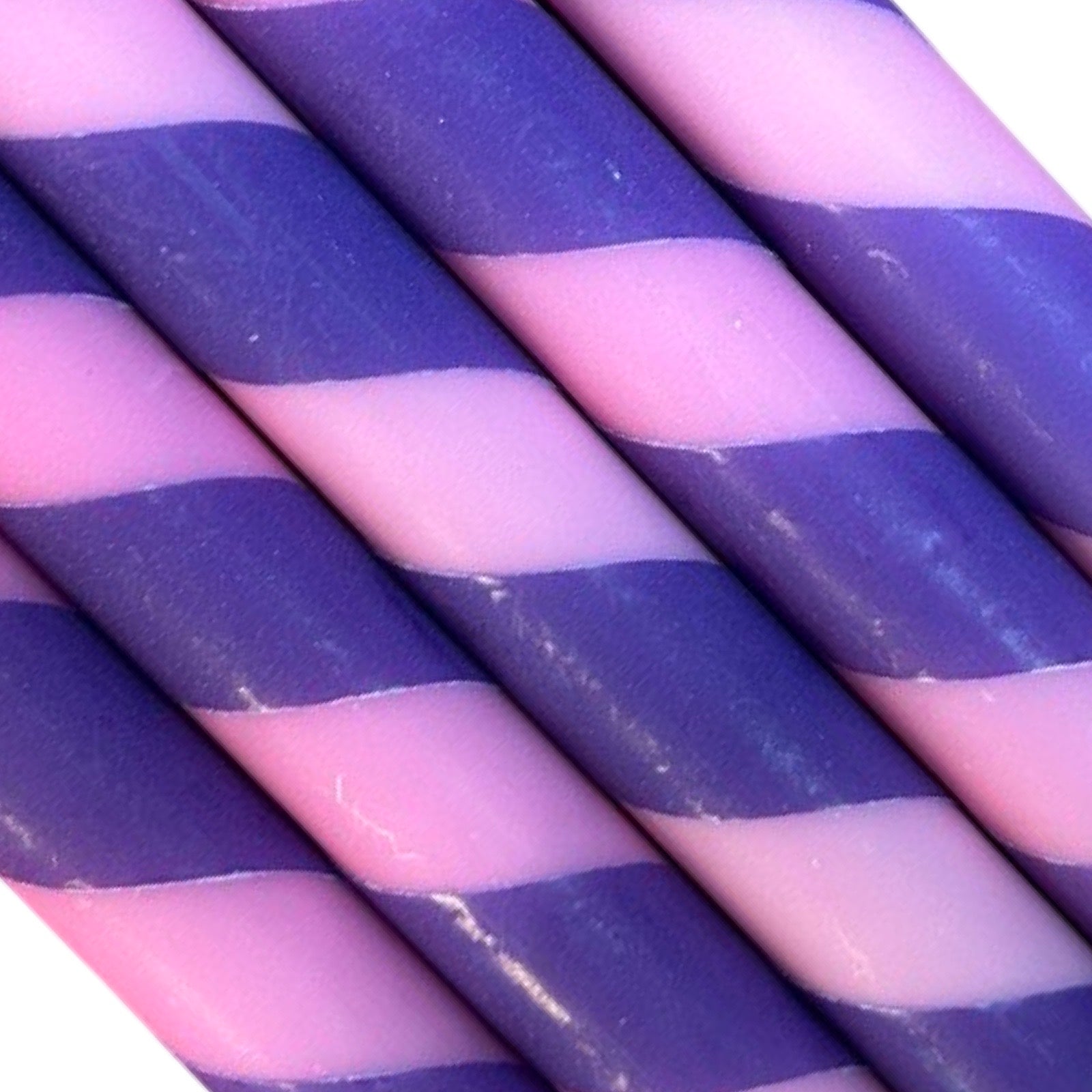 An image of five candles with rose and purple stripes.