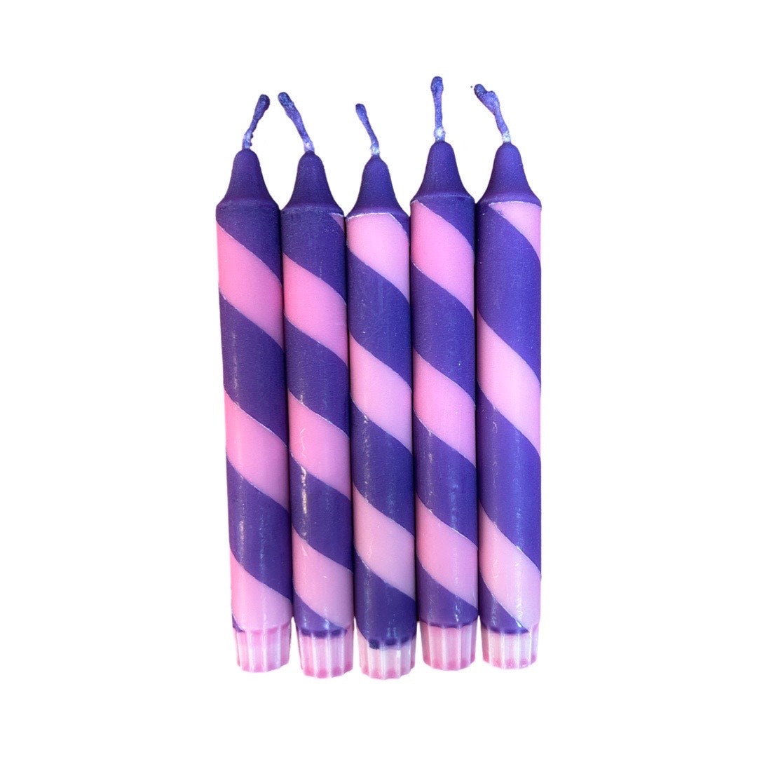 An image of five candles with rose and purple stripes.