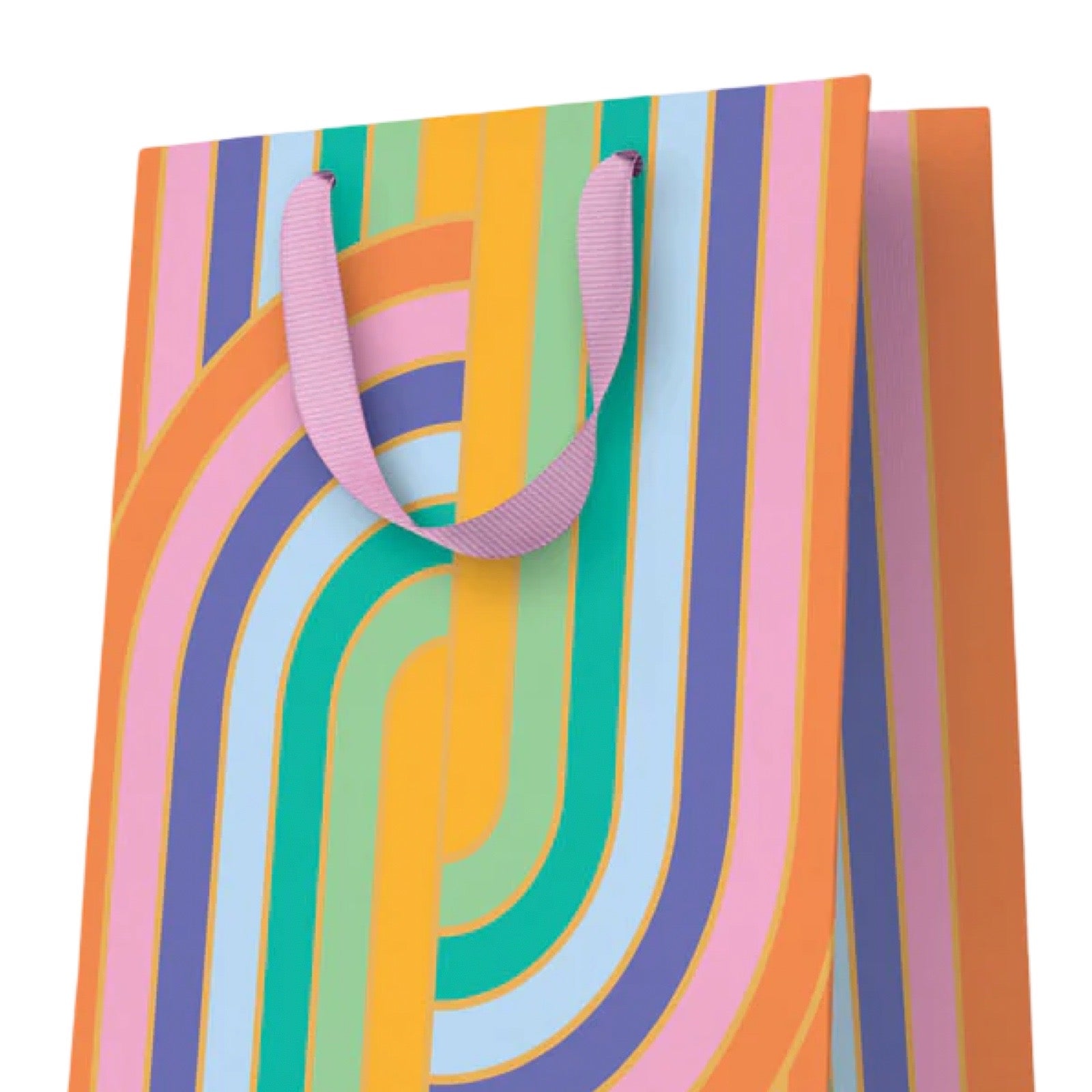 A colourful paper gift bag with a retro wavy stripe pattern in pink, orange, yellow, green, blue, and purple, with pink ribbon handles, shown on a plain white background.
