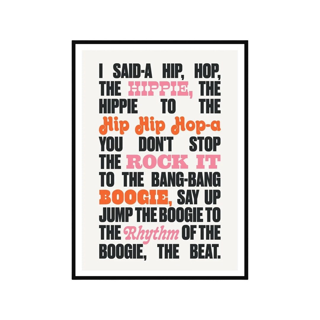 Typography print of the lyric 'I said-a hip, hop, the hippie, the hippie to the hip, hip, hop-a you don't stop the rock it to the bang-bang boogie, say up jump the boogie to the rhythm of the boogie, the beat' from the song Rappers Delight by the Sugarhill Gang. The words 'hippie', 'rock it' and 'rhythm' are written in pink text, the words 'hip, hip, hop-a' and 'boogie' in red text and the rest of the text in black, all on an off-white background