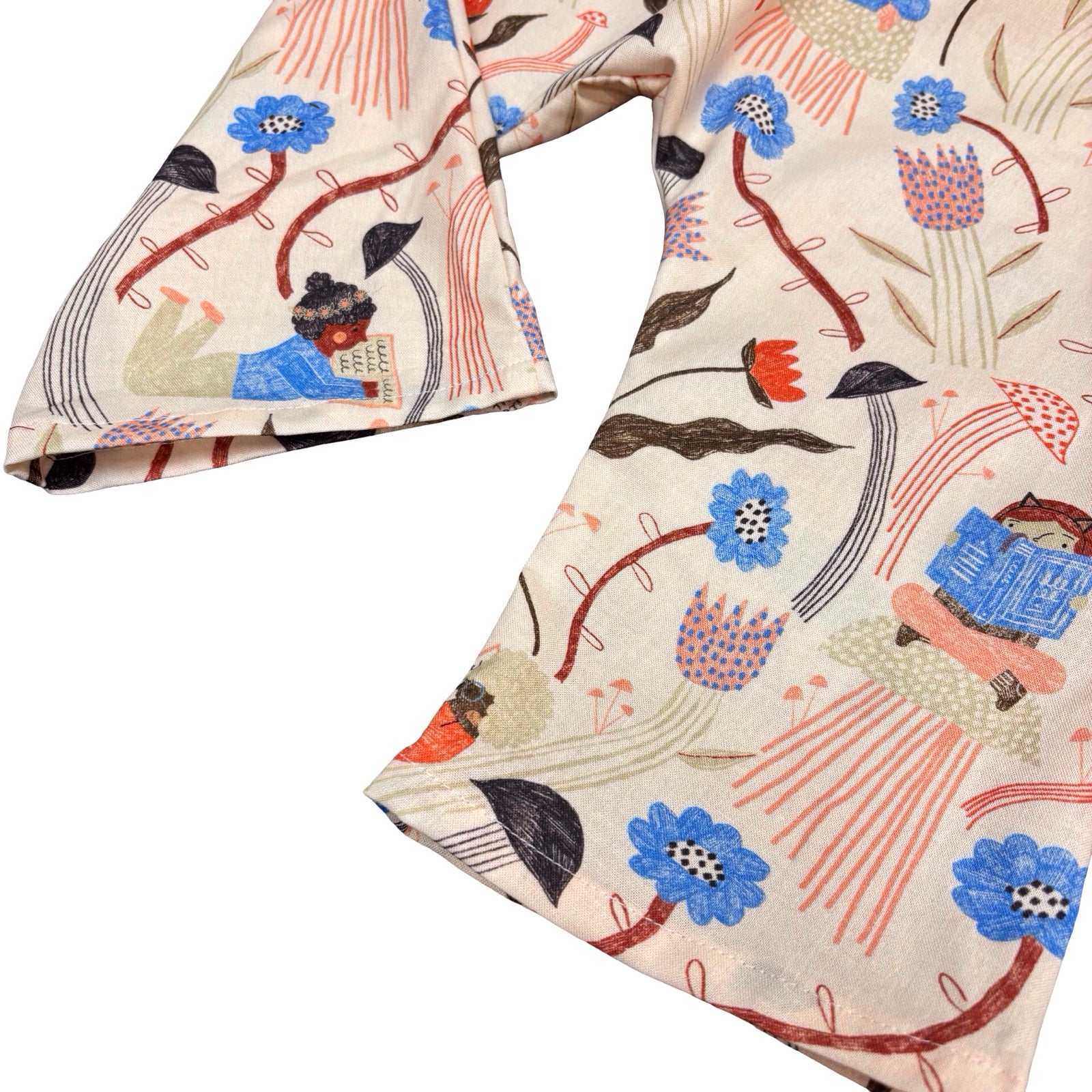 Bottom of trousers with a colourful pattern featuring people, flowers, and books on a white background.