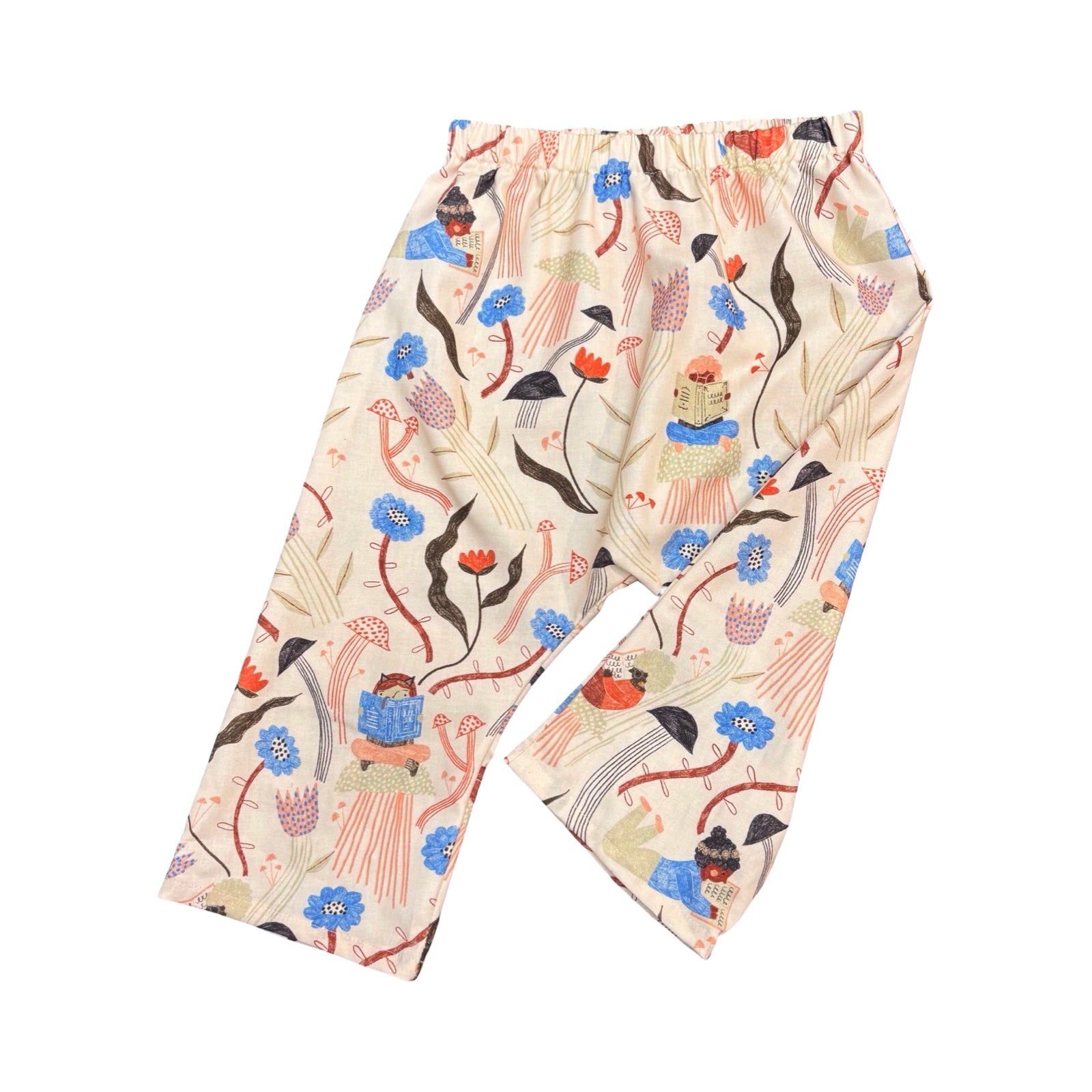 Colourful floral and book patterned pants on a white background.