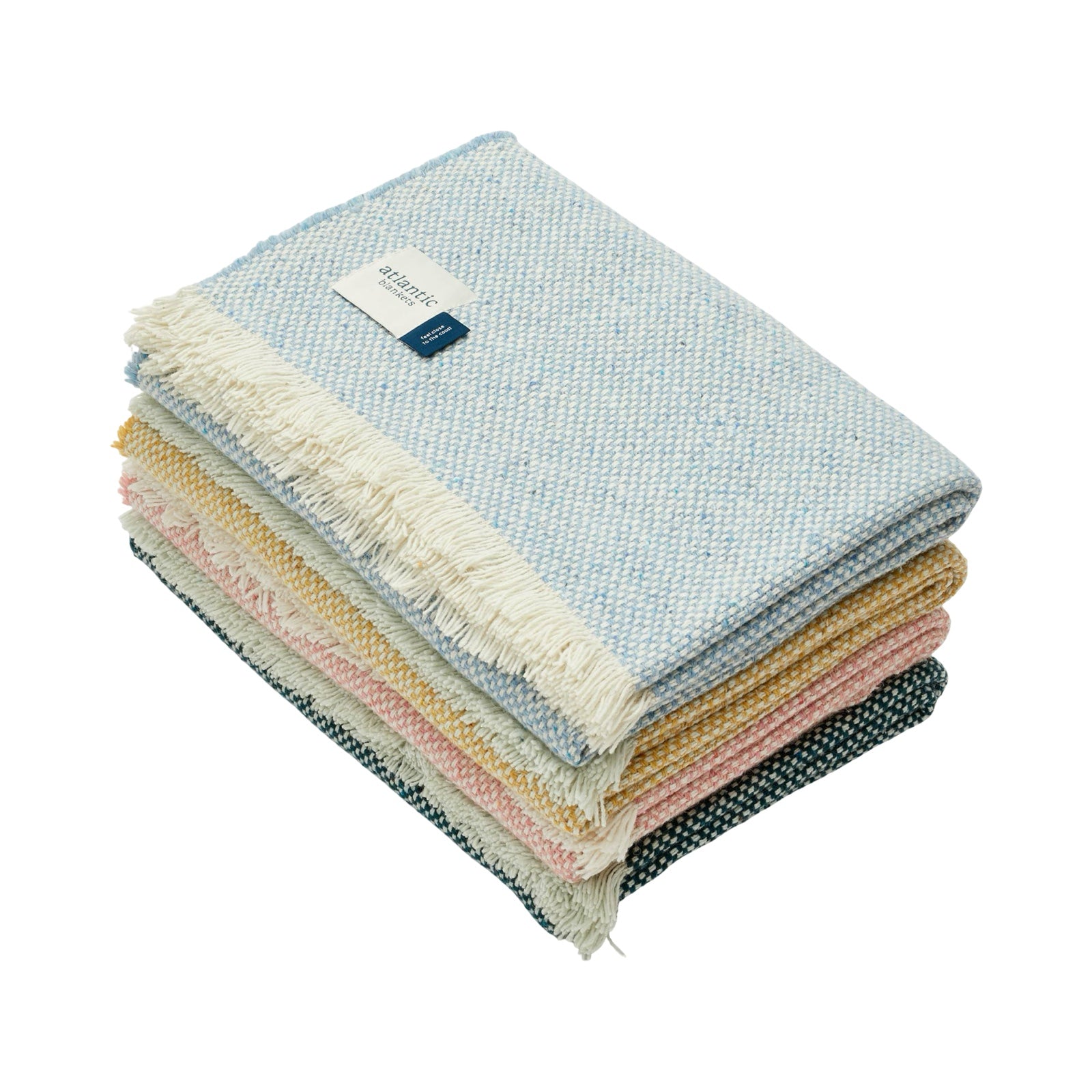 Stack of colorful textured blankets with a brand label on a white background