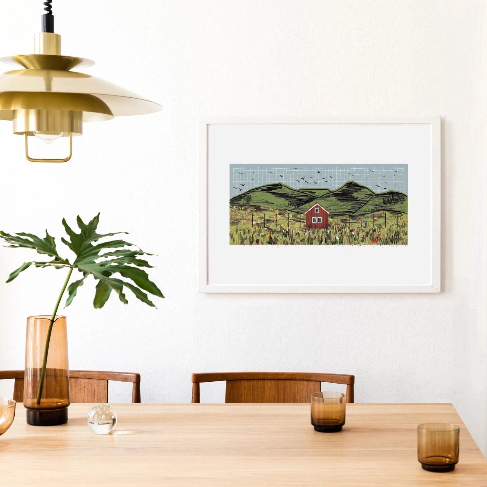 Dining room with wooden table, chairs, and a framed landscape print on the wall.