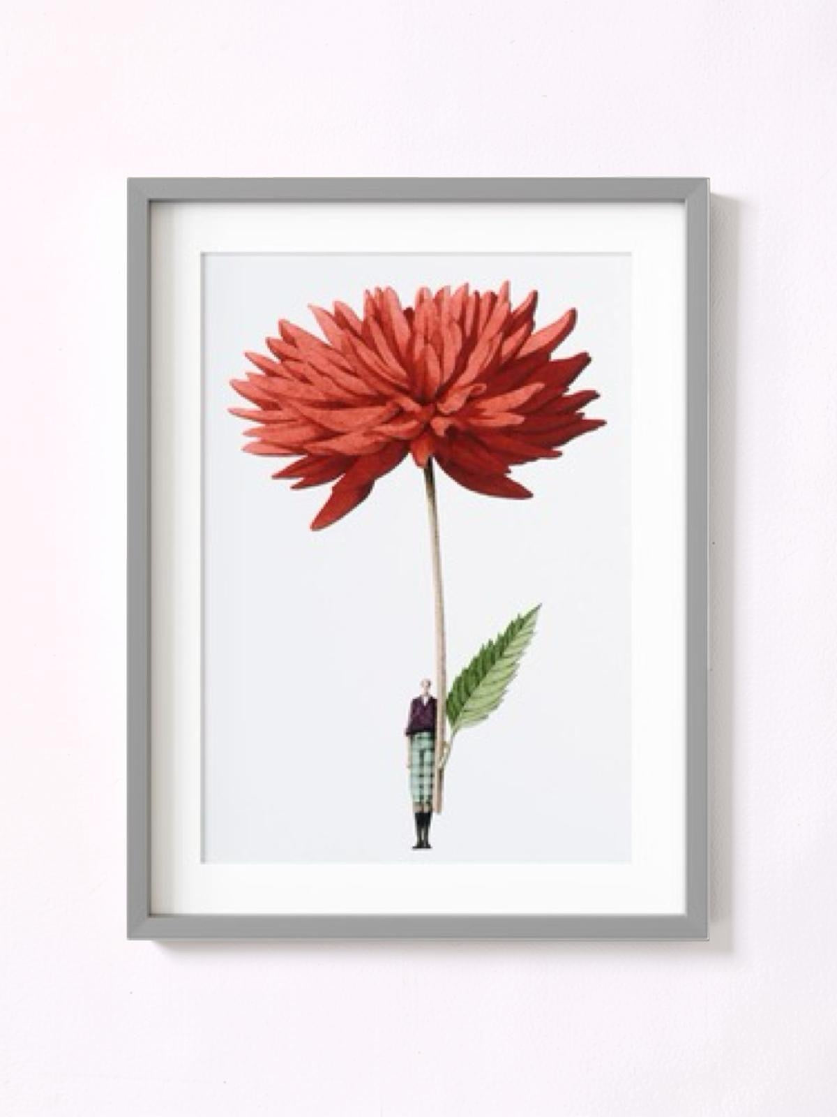 Framed artwork of a red flower with a small figure underneath on a white background.