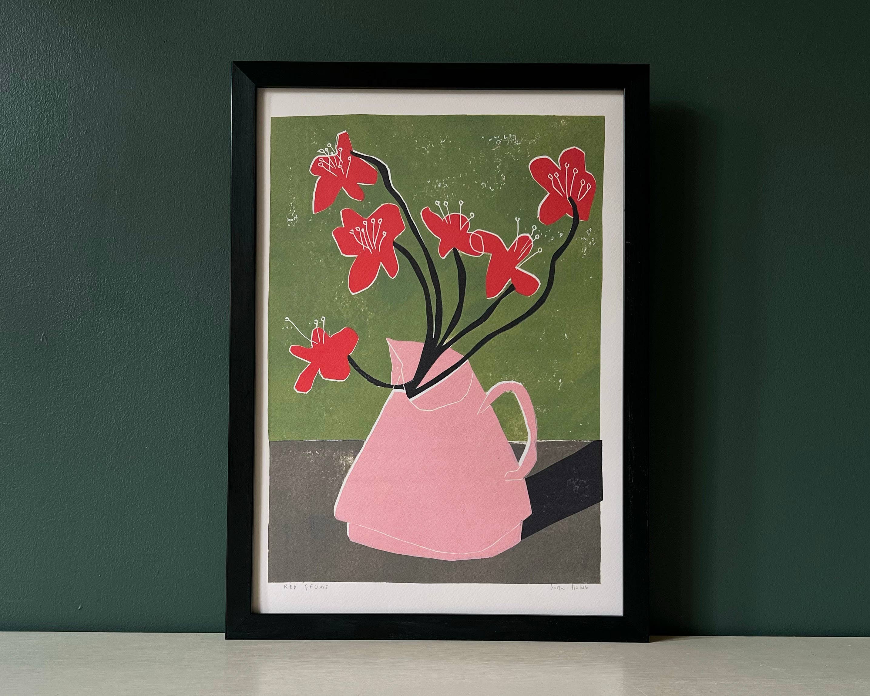 Framed artwork of a pink vase with red flowers on a green background.