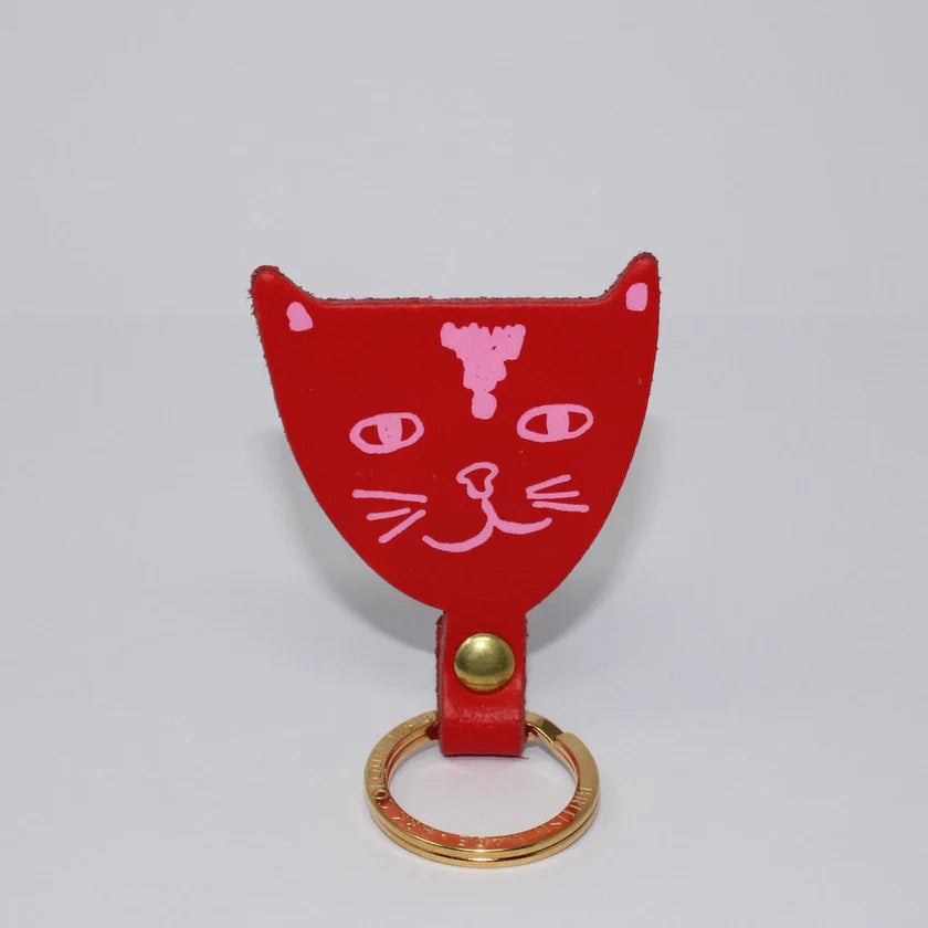 Red cat-shaped keyring with pink details on a light grey background.
