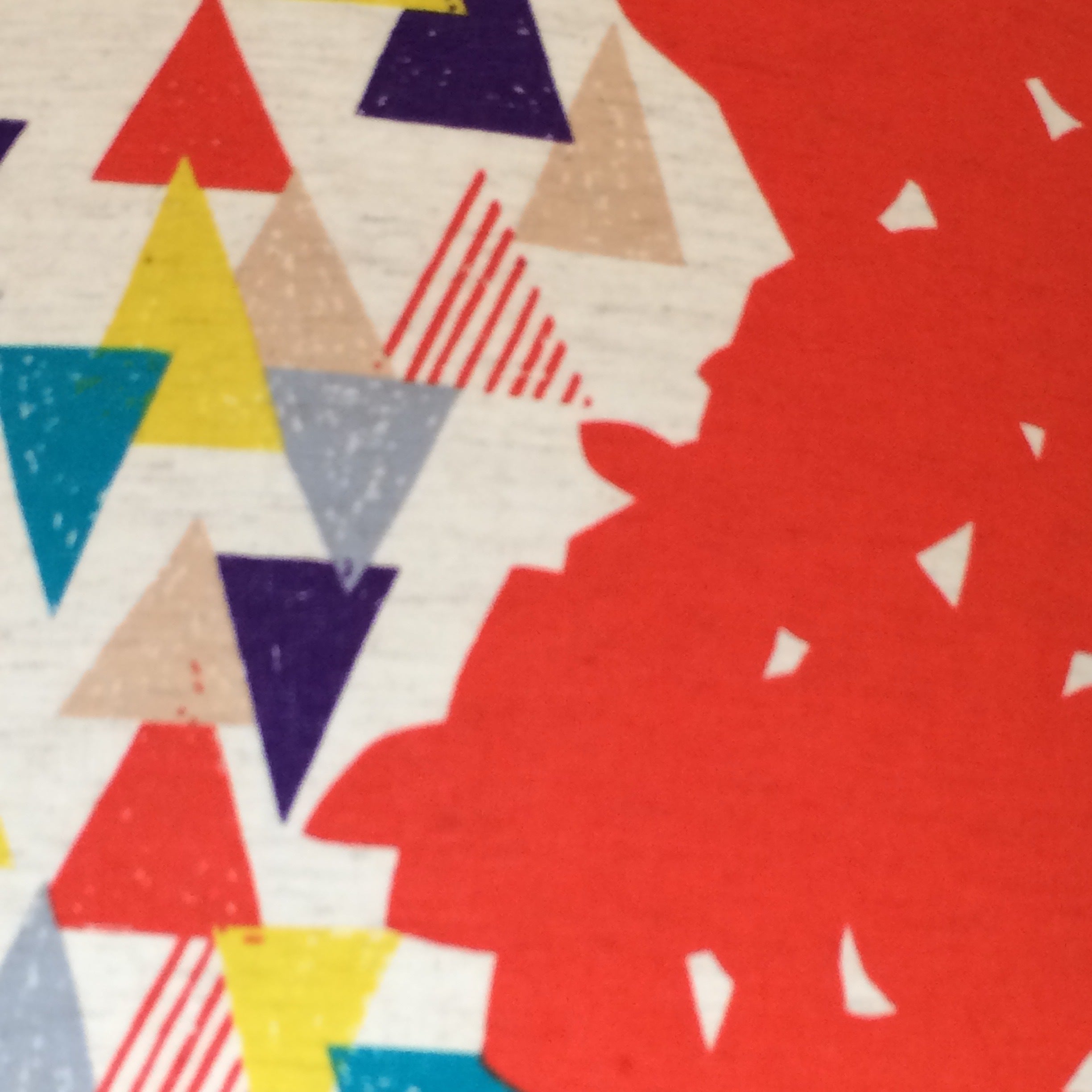 Drum lampshade covered in Echino cotton featuring a red background with panels of multicolured triangles and light brown birds.