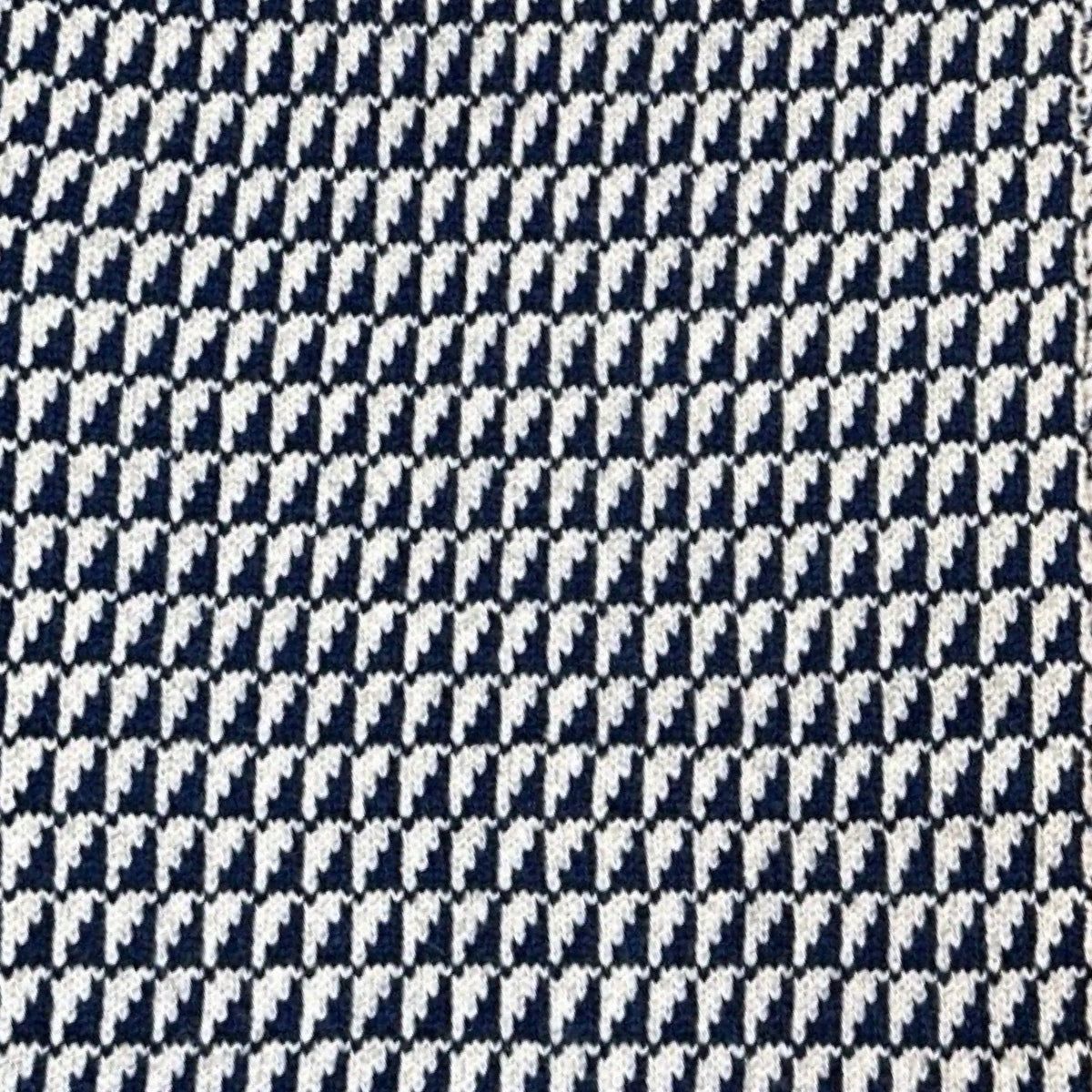 A close-up of a woven fabric pattern in navy blue and off-white.