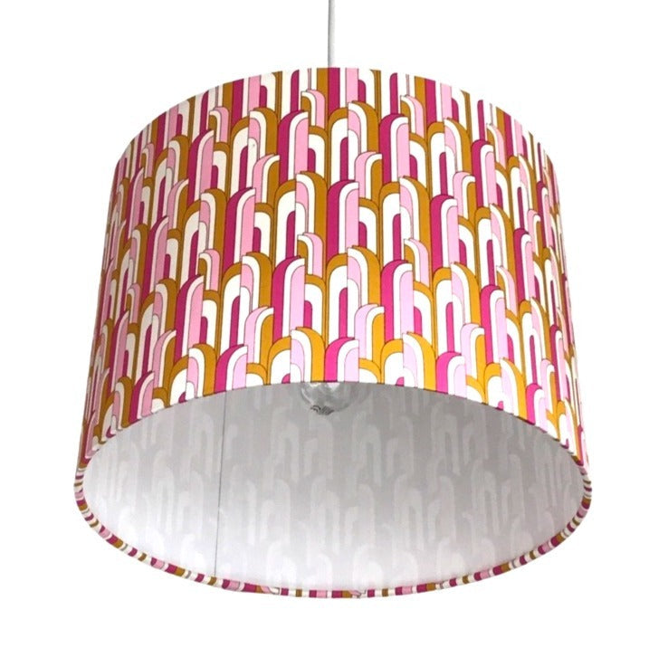 Close up of a drum lampshade in a pink, white and mustard mid-century-inspired retro arch design