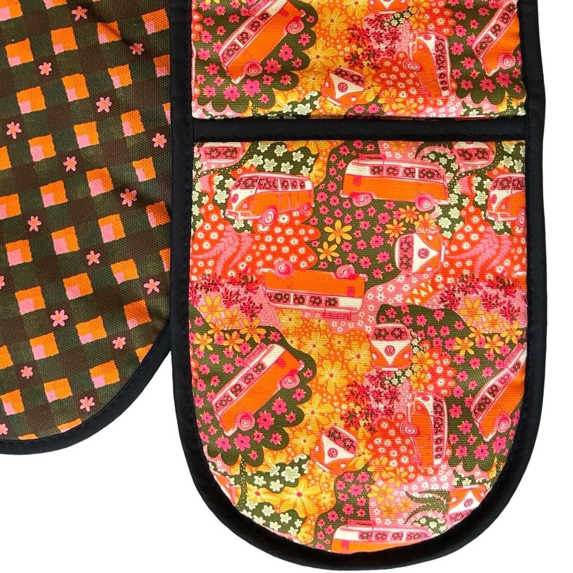 Oven gloves with a repeat pattern illustration of an orange and cream VW campervan against a floral backdrop on the front and a checked pink, orange, green and black patterned reverse.