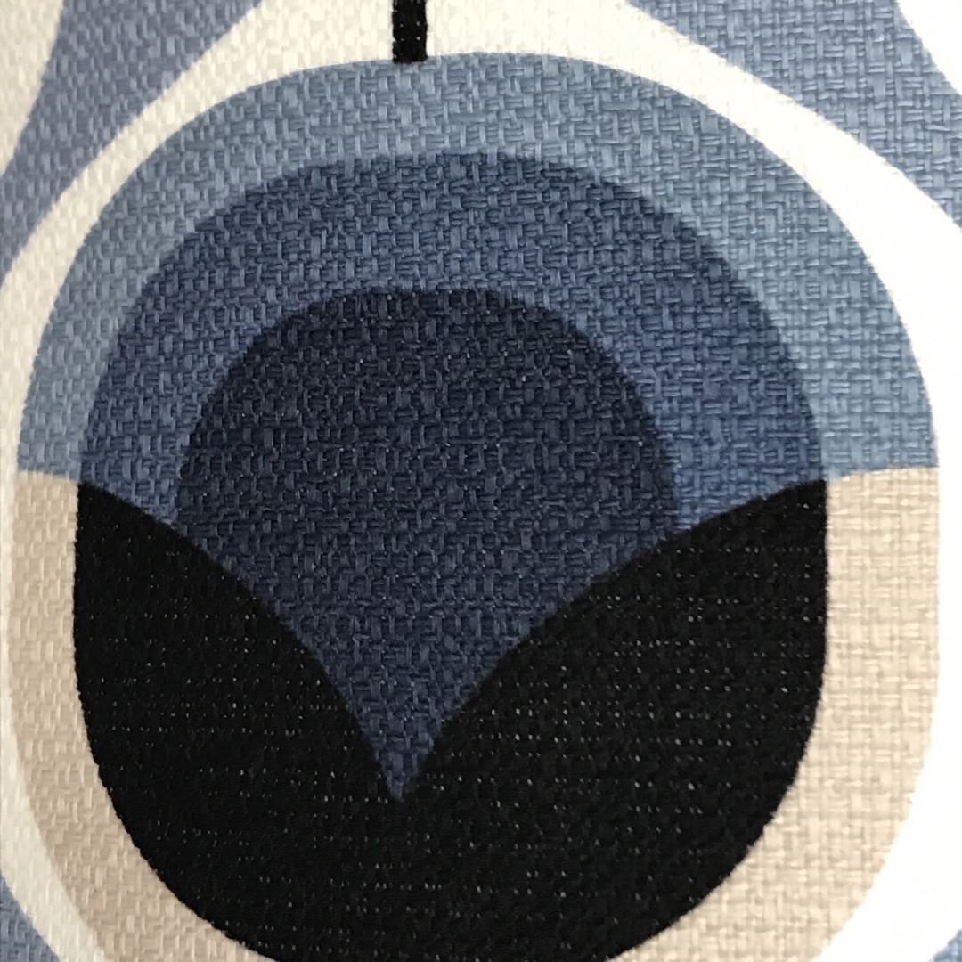 A cushion cover with a retro abstract floral design in blue and grey.