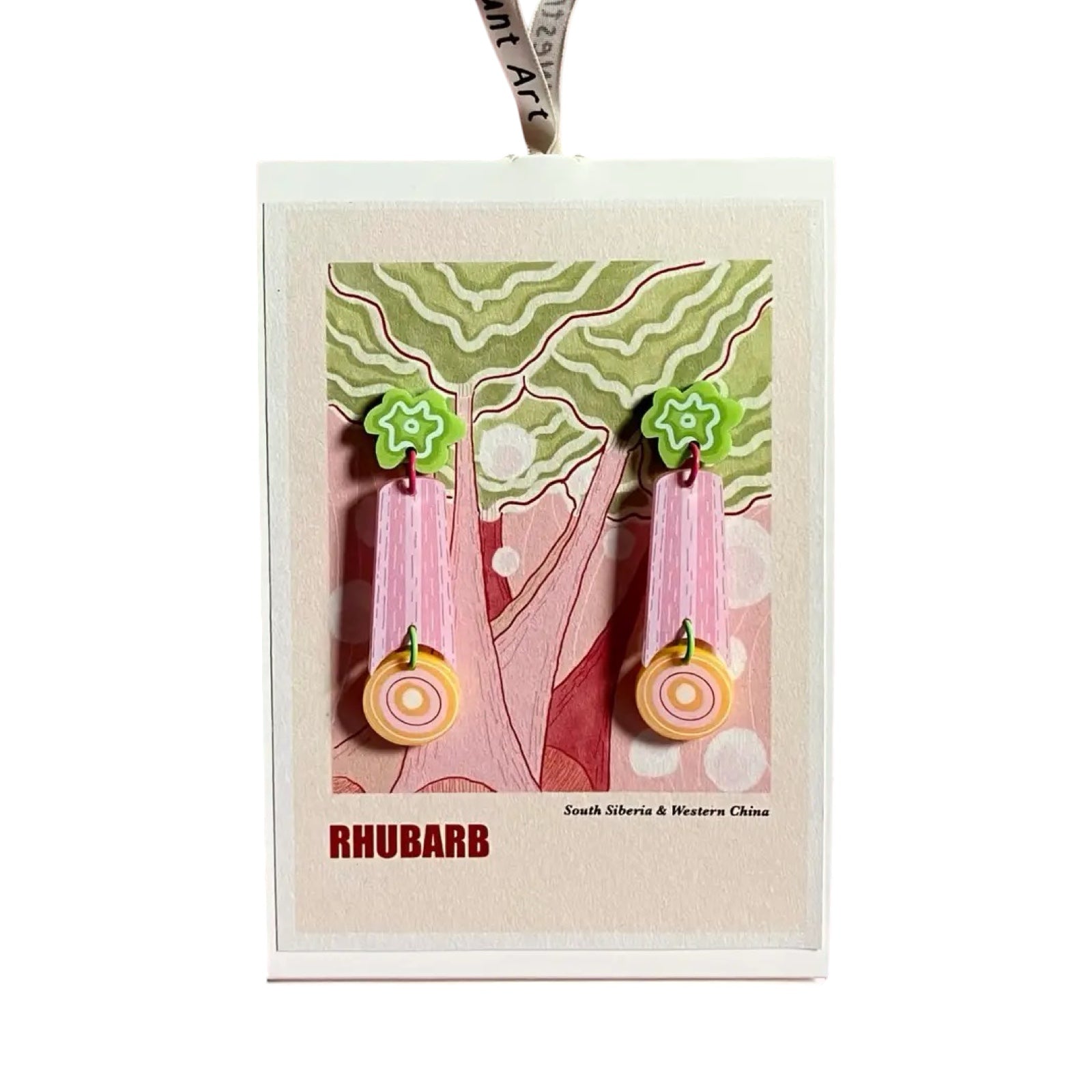 A pair of earrings with green studs, purple dangles and yellow circles at the ends on a backing card.