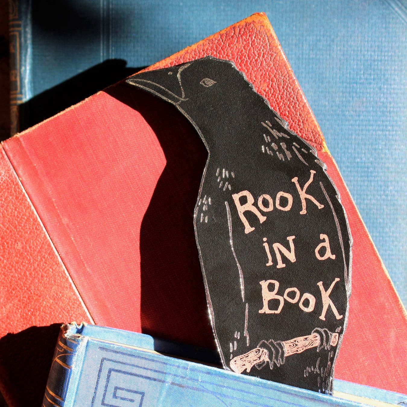 Decorative bookmark shaped like a rook on top of two books.