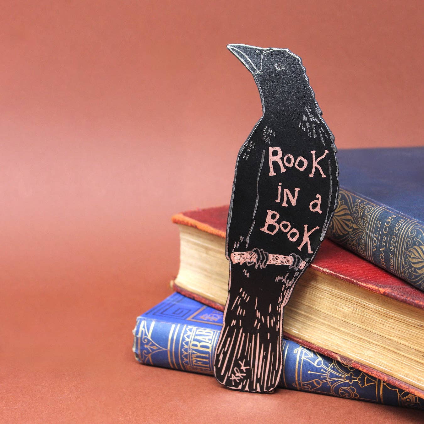 Decorative bookend shaped like a crow with 'Rook in a Book' text on top of books.