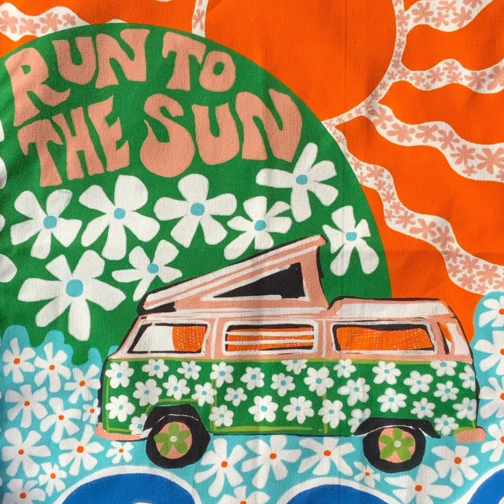 A statement tea towel featuring retro van with floral green design, surrounded by an orange sun and blue waves. The text 'Run To The Sun' sits in a green circle with white flowers.