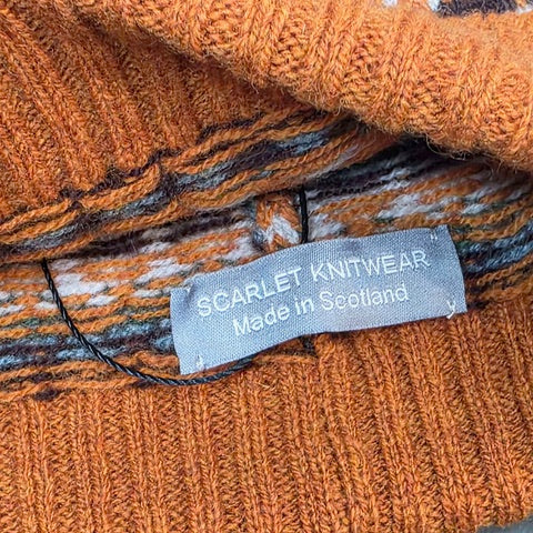 This orange, navy, blue and white striped woollen hat is handmade using only the softest Scottish spun lambswool.