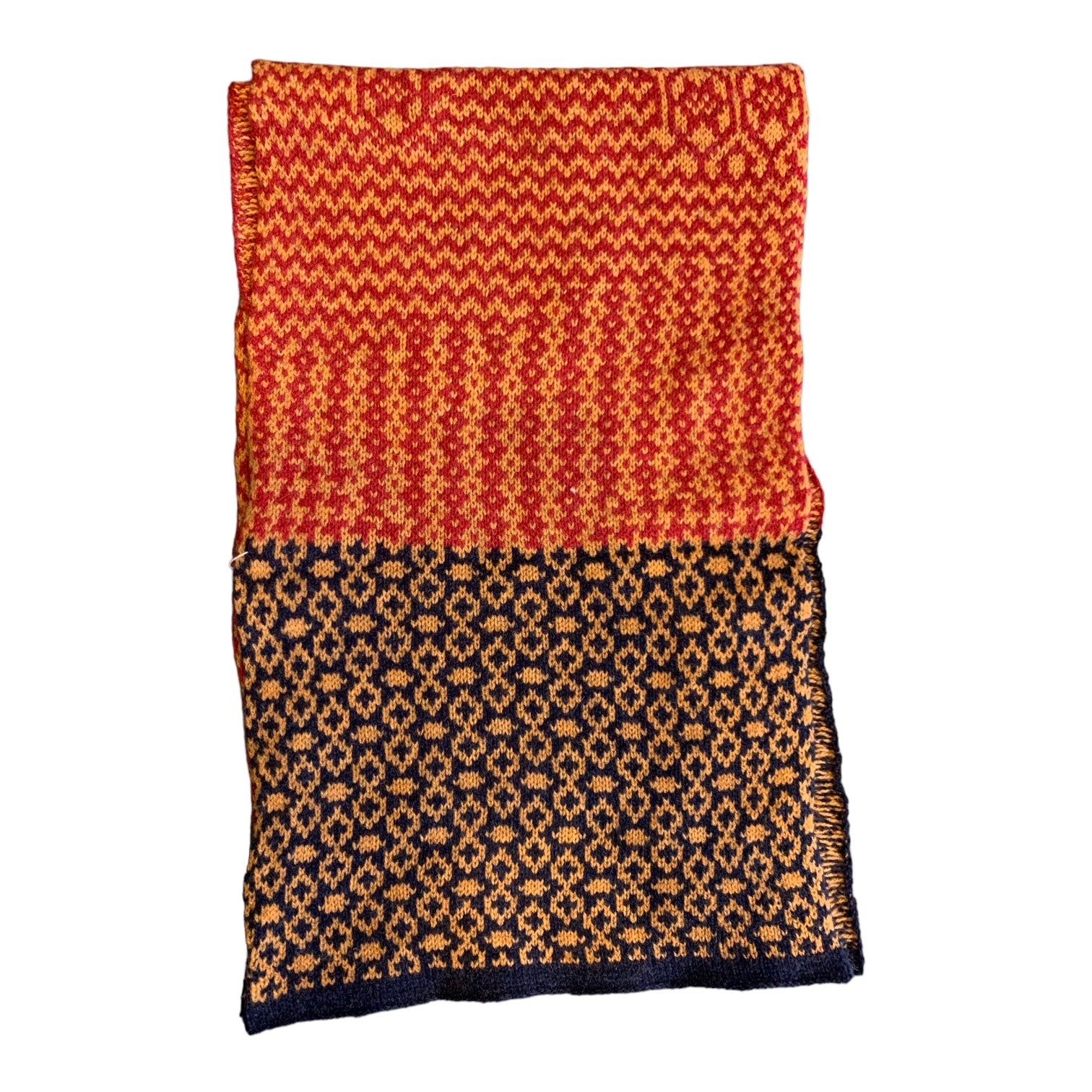 A cosy and soft 100% lambswool knitted scarf with an orange, red and black geometric design.