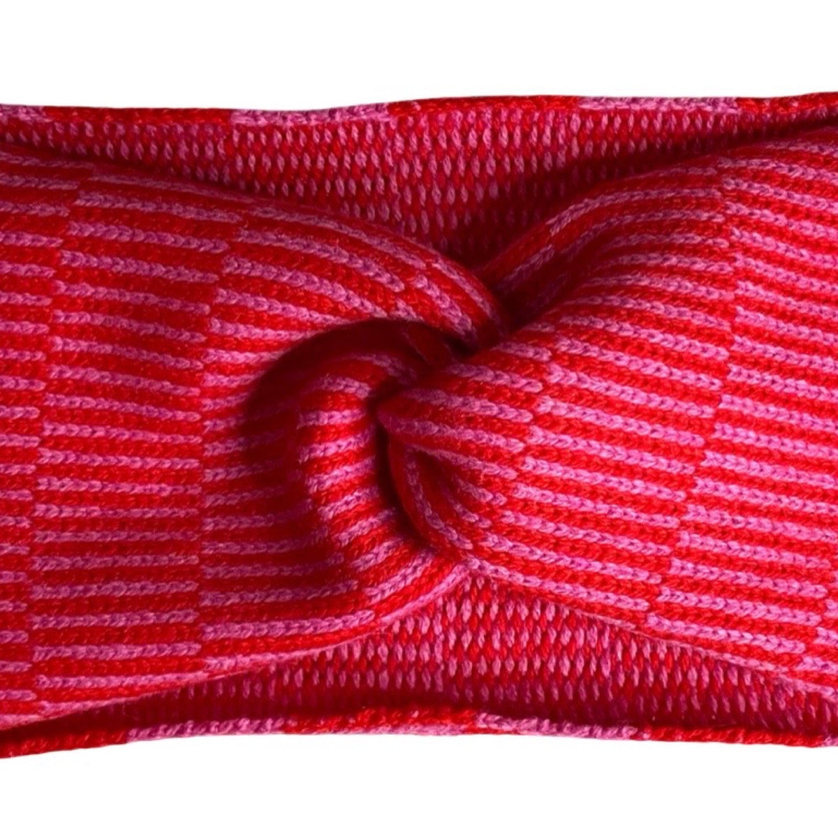 A close-up of a red and pink striped knit fabric headband, twisted in the centre against a white background.