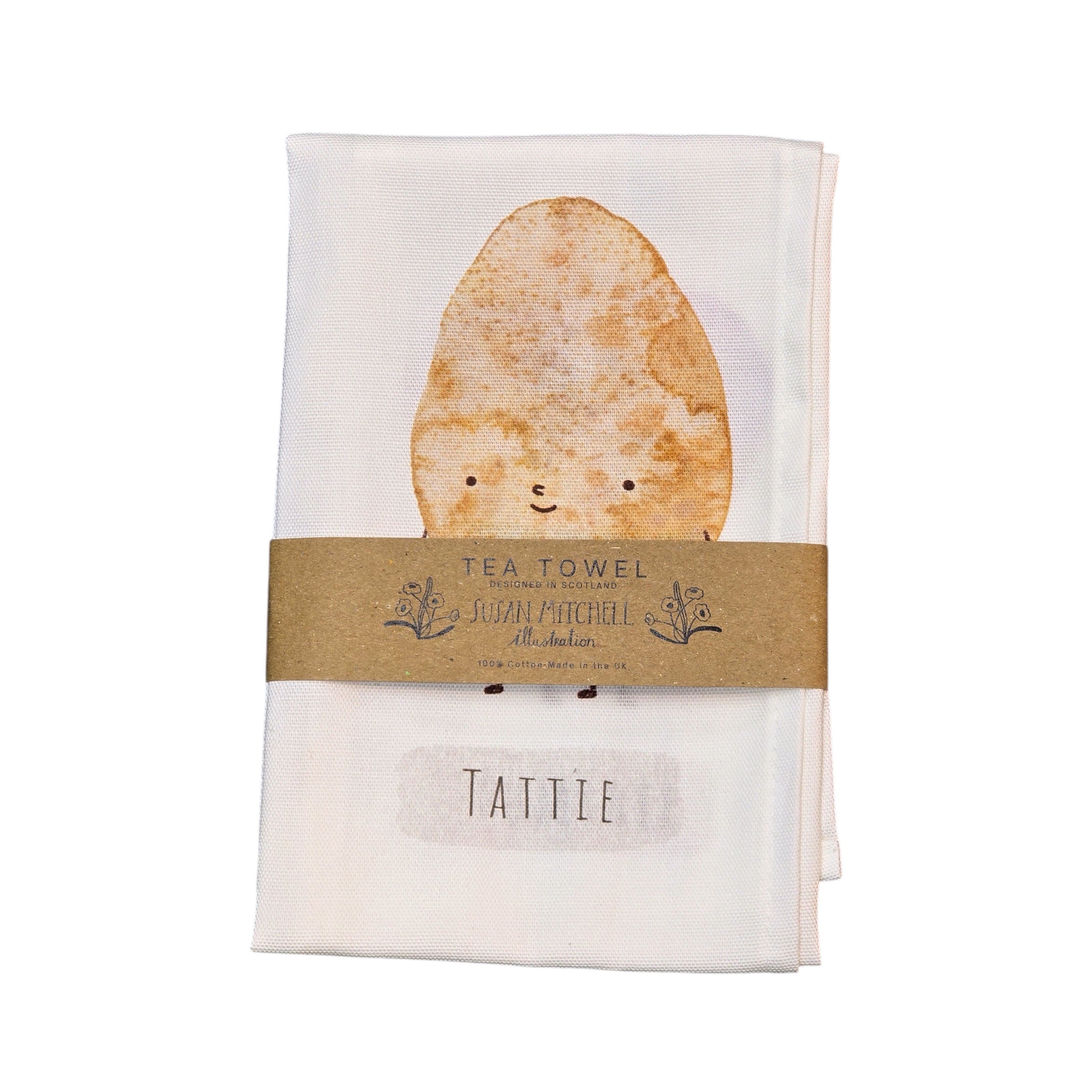 An image of a tea towel with a smiling tattle illustration on the front.